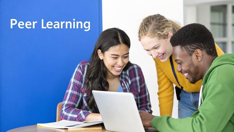 Three diverse young students happily collaborate on a laptop, engaged in peer learning.