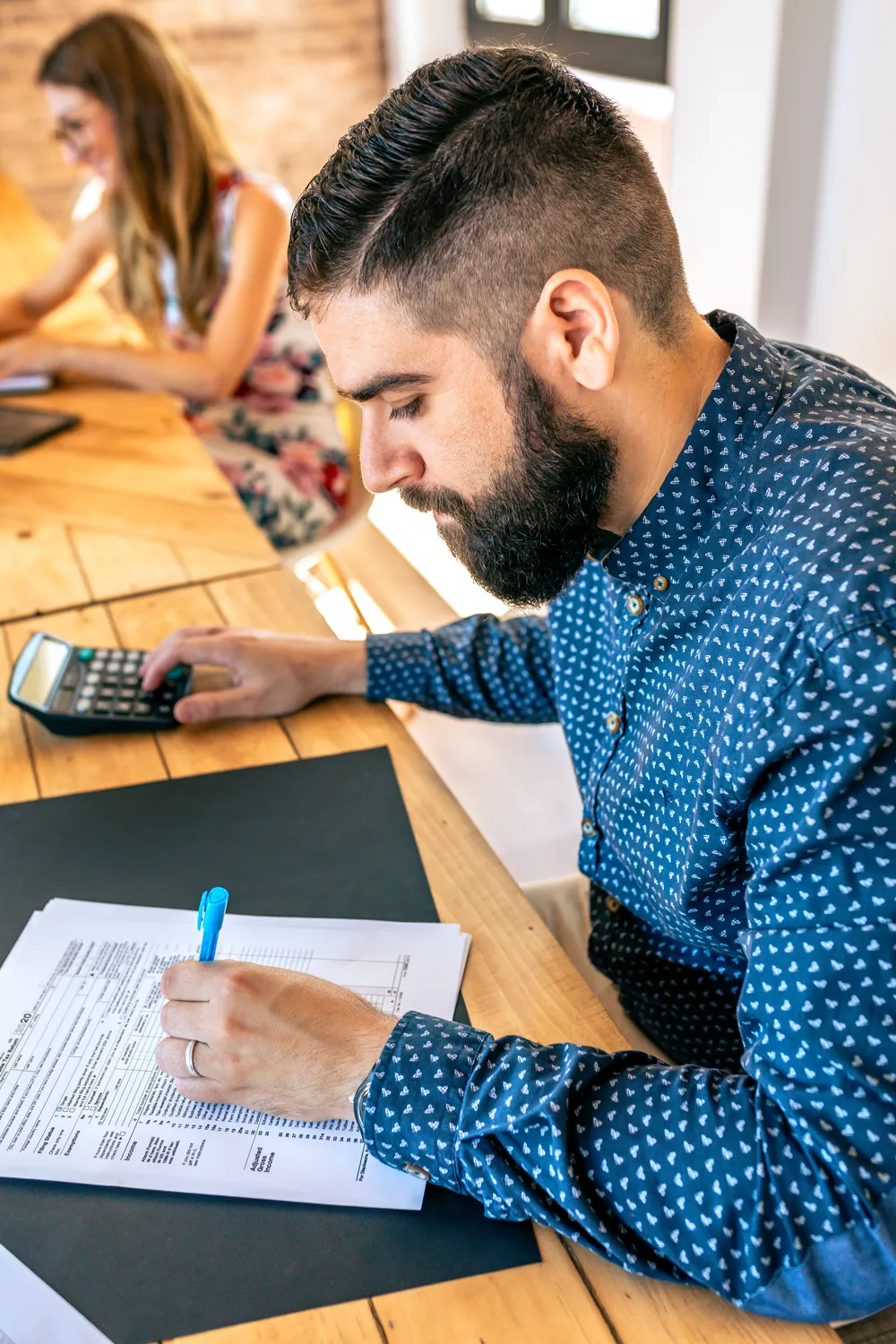 Man doing calculations with a calculator