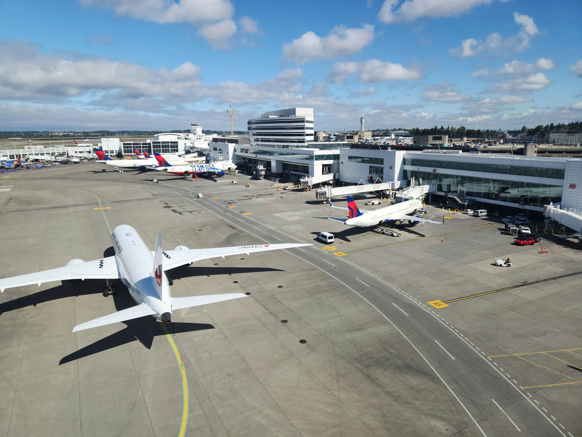 Commercial airplane taxiing on the runway at a major international airport terminal.