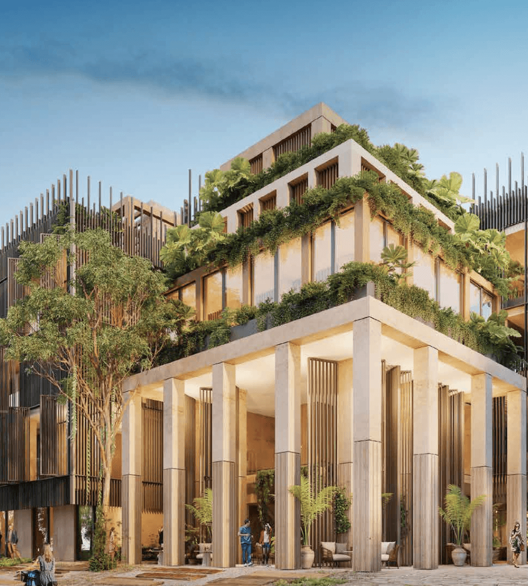 A smiling young man with crossed arms, wearing a plaid shirt and white t-shirt, poses against a dark background.