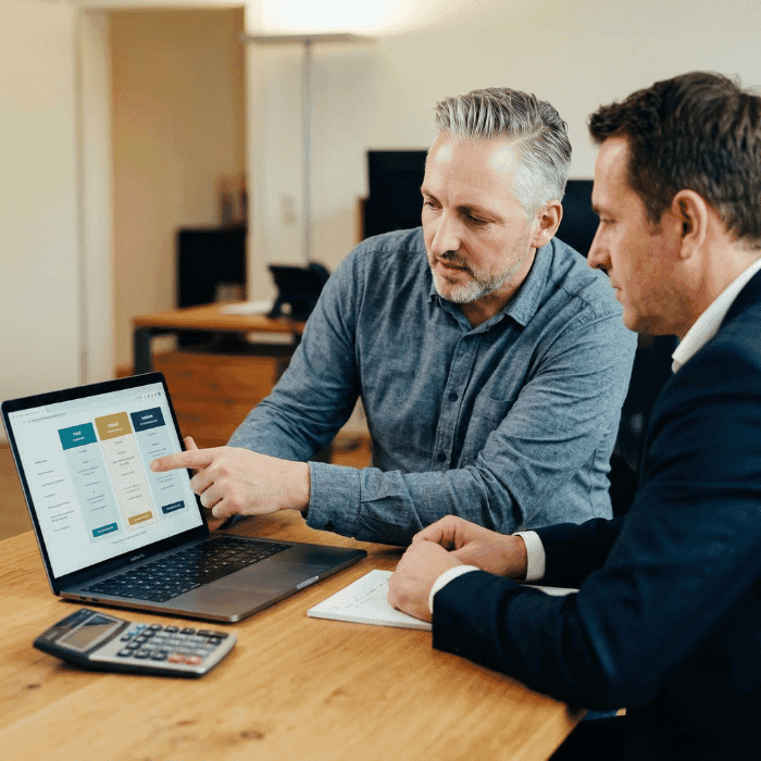 Hannes Weindorf zeigt einem Geschäftsführer die drei steuerlichen Wege der bKV am Laptop