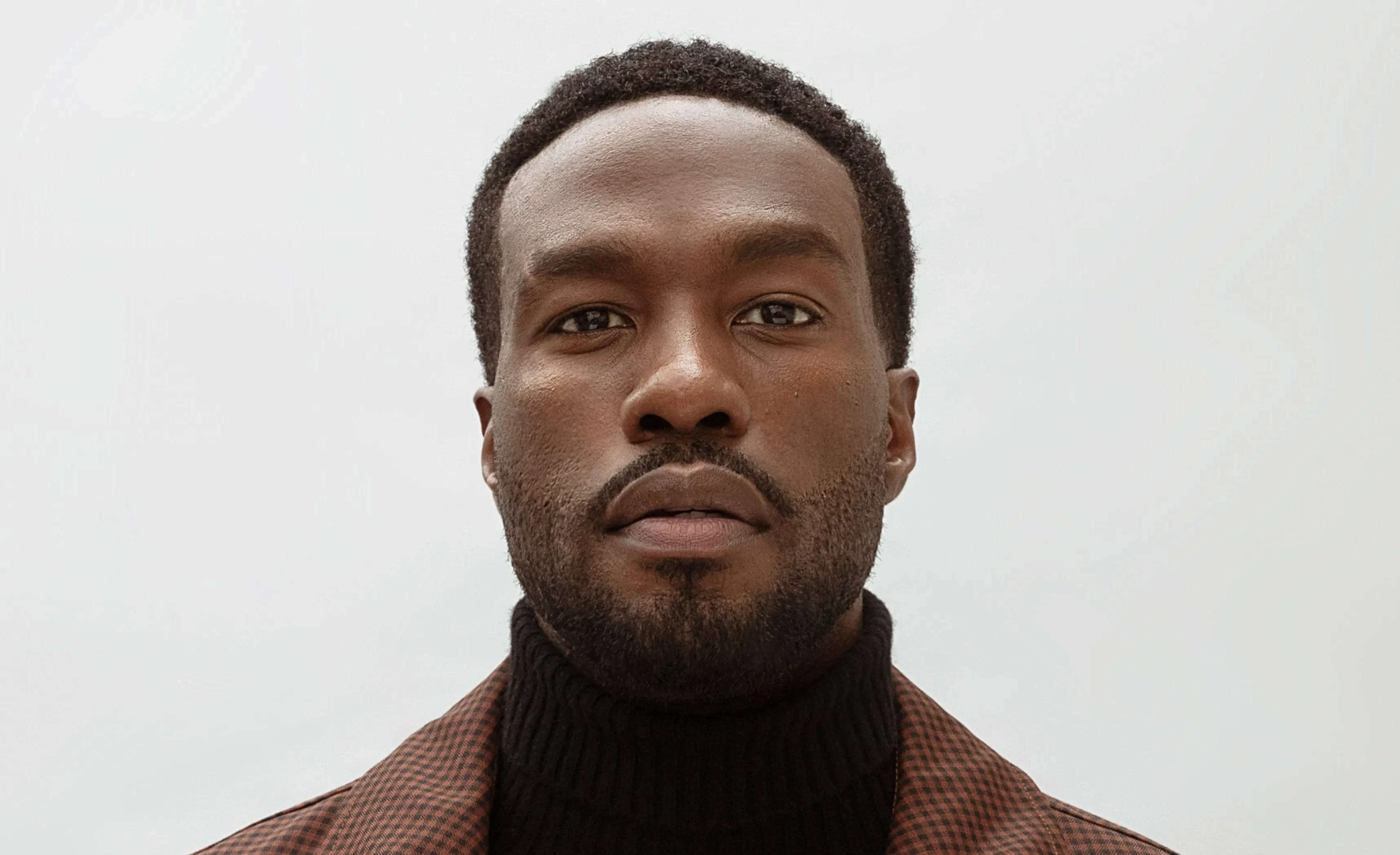 man wearing green crew-neck top and eyeglasses with black frames looking at side