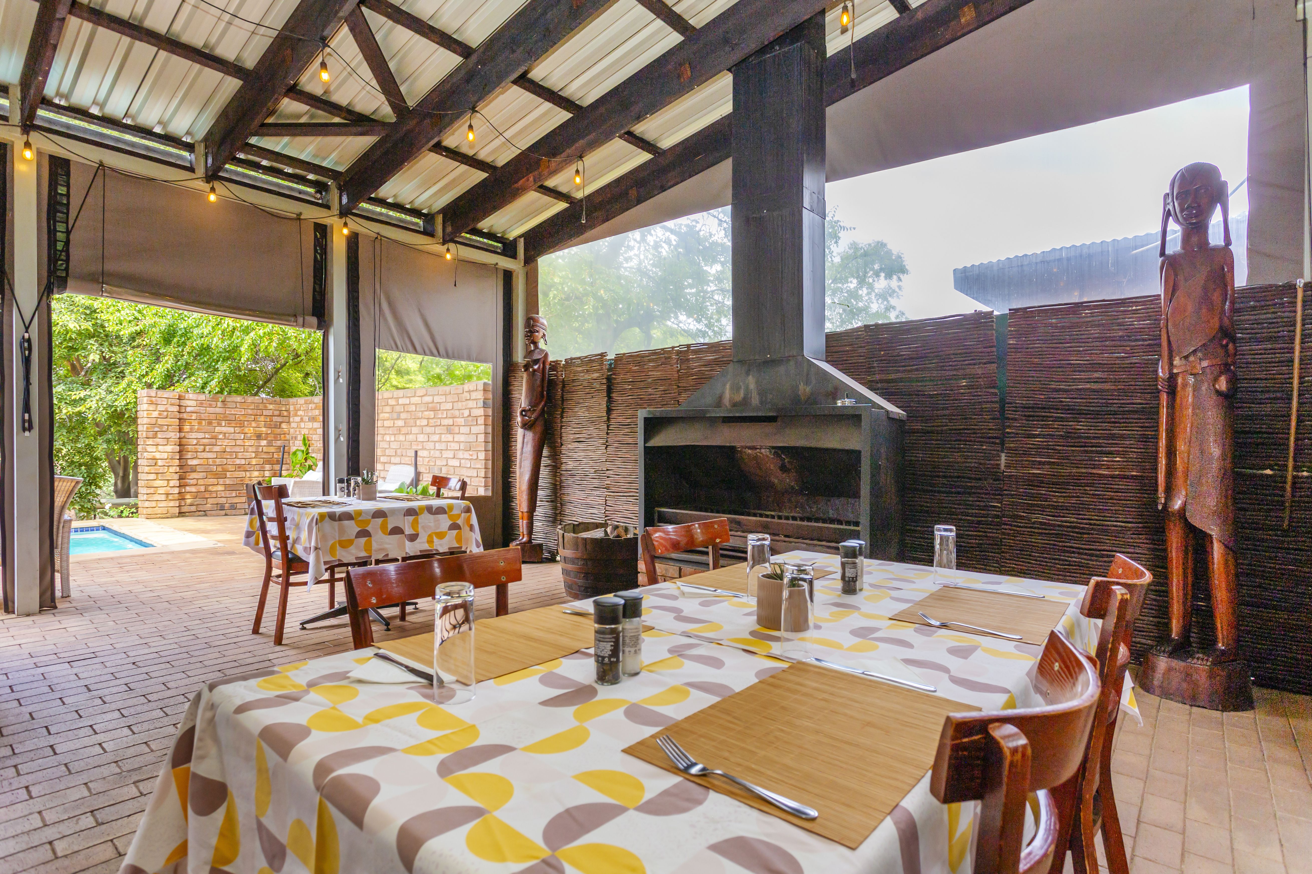 Kilimanjaro Elephant Ride, Arusha, Tanzania. En kvinna sitter och läser utanför ett tält uppsatt i vildmarken.