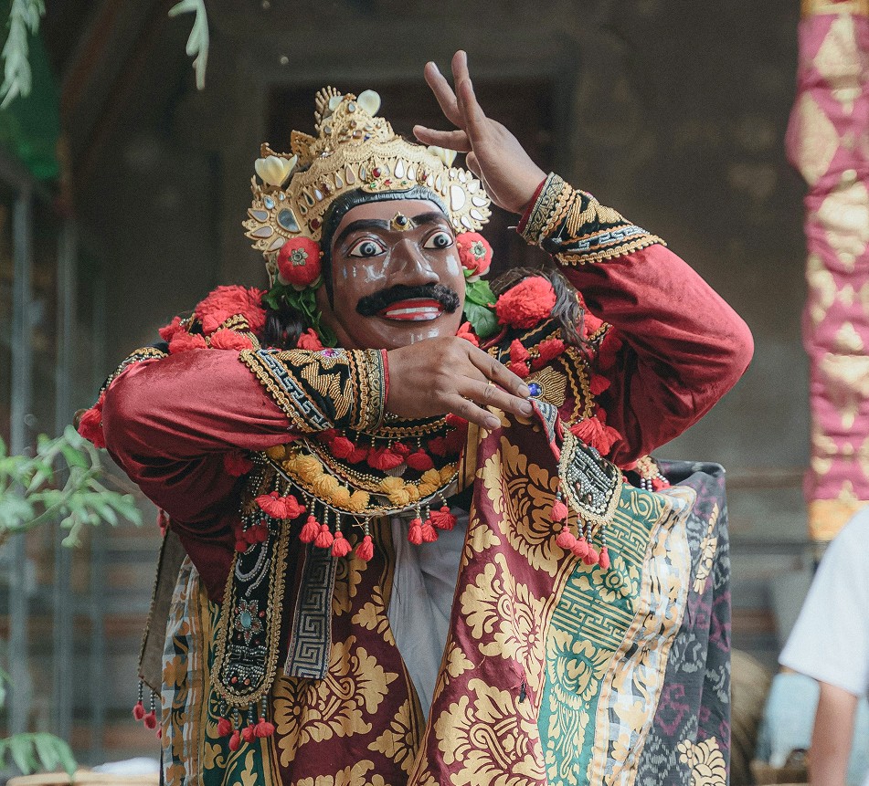 A masked Balinese dancer in traditional costume