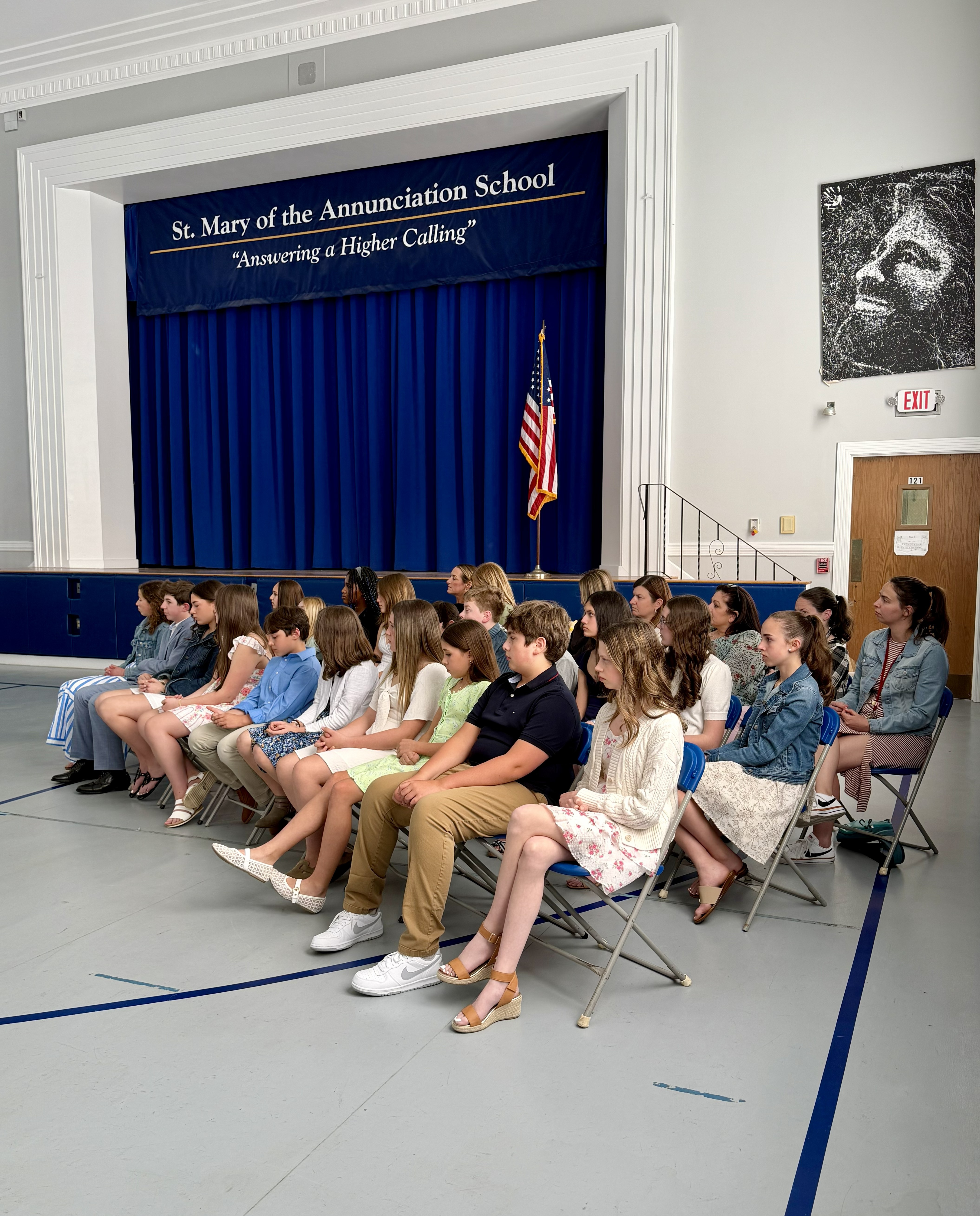 Students and families seated in the gym for a school assembly