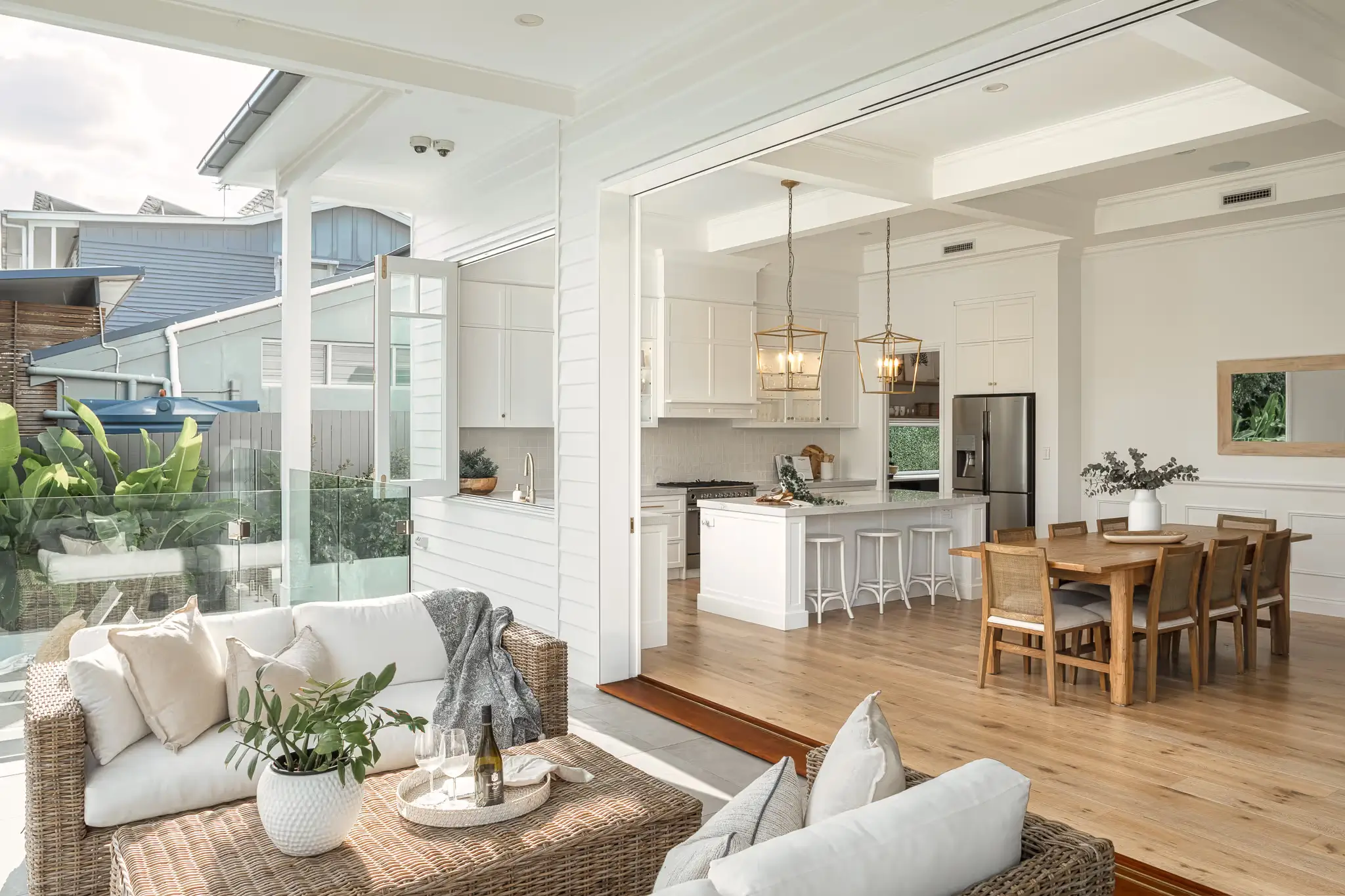 An outdoor entertainment area with a view into the indoor outdoor flow with the kitchen and dining