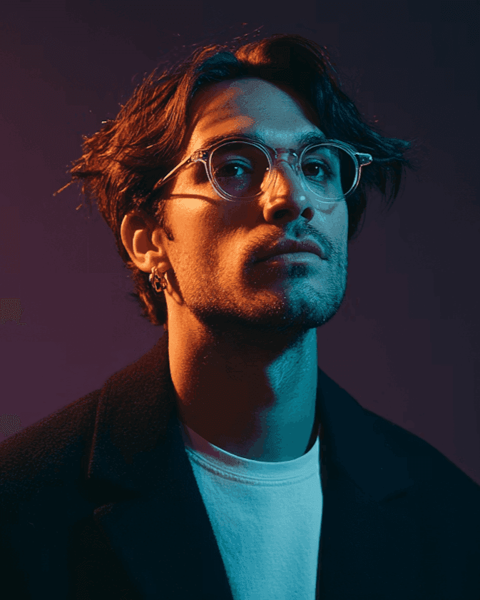 Portrait of man with glasses under teal and orange studio lighting