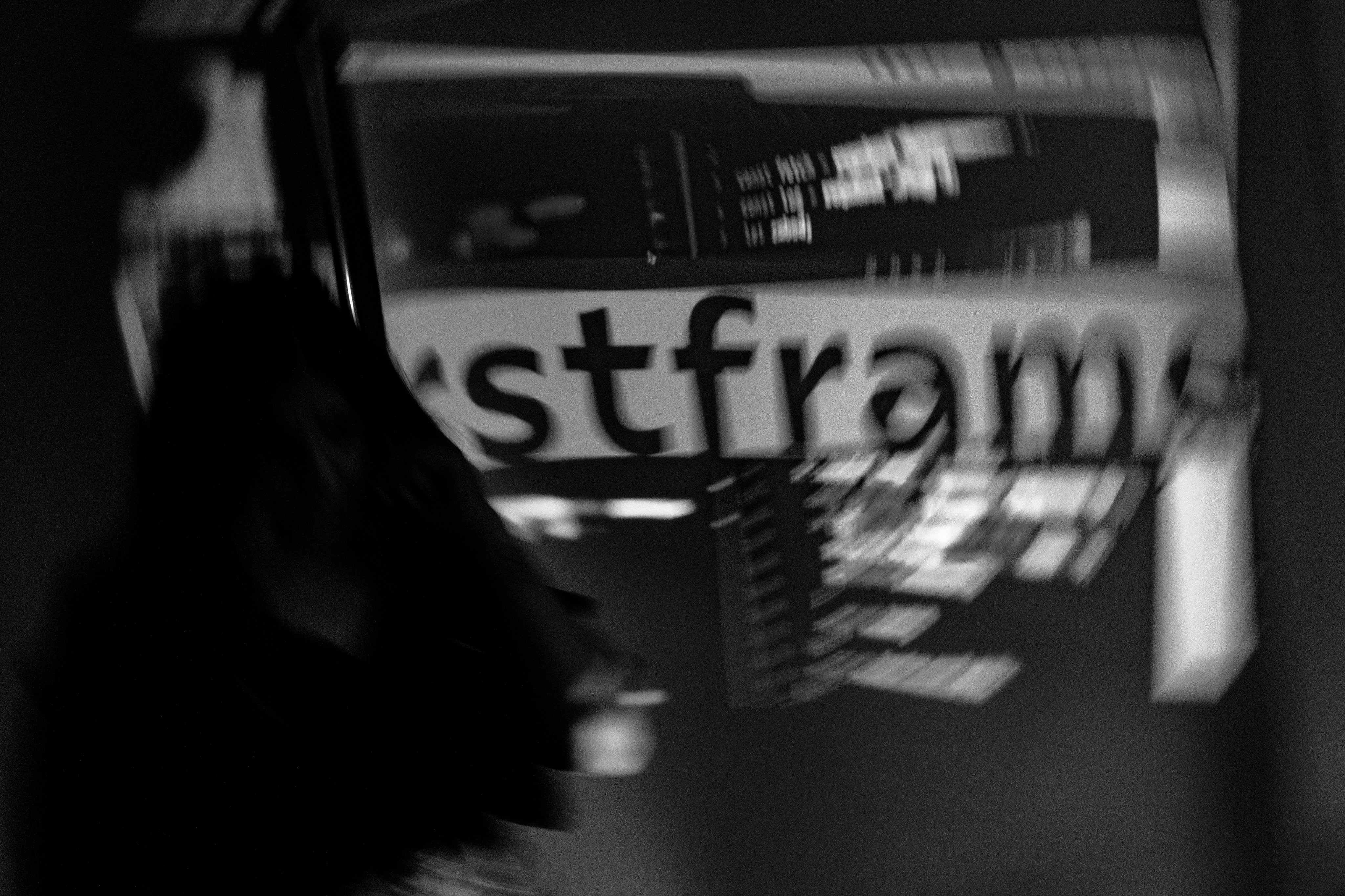 Black and white image of people working at a table with laptops, showing hands gesturing during discussion of digital content displayed on screens, with fabrica® logo in the corner.