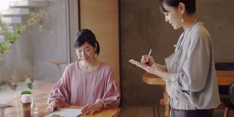 A F&B business staff taking food orders from her customer