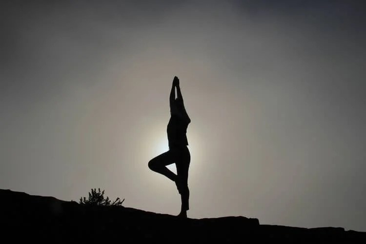 a silhouette of a person doing yoga
