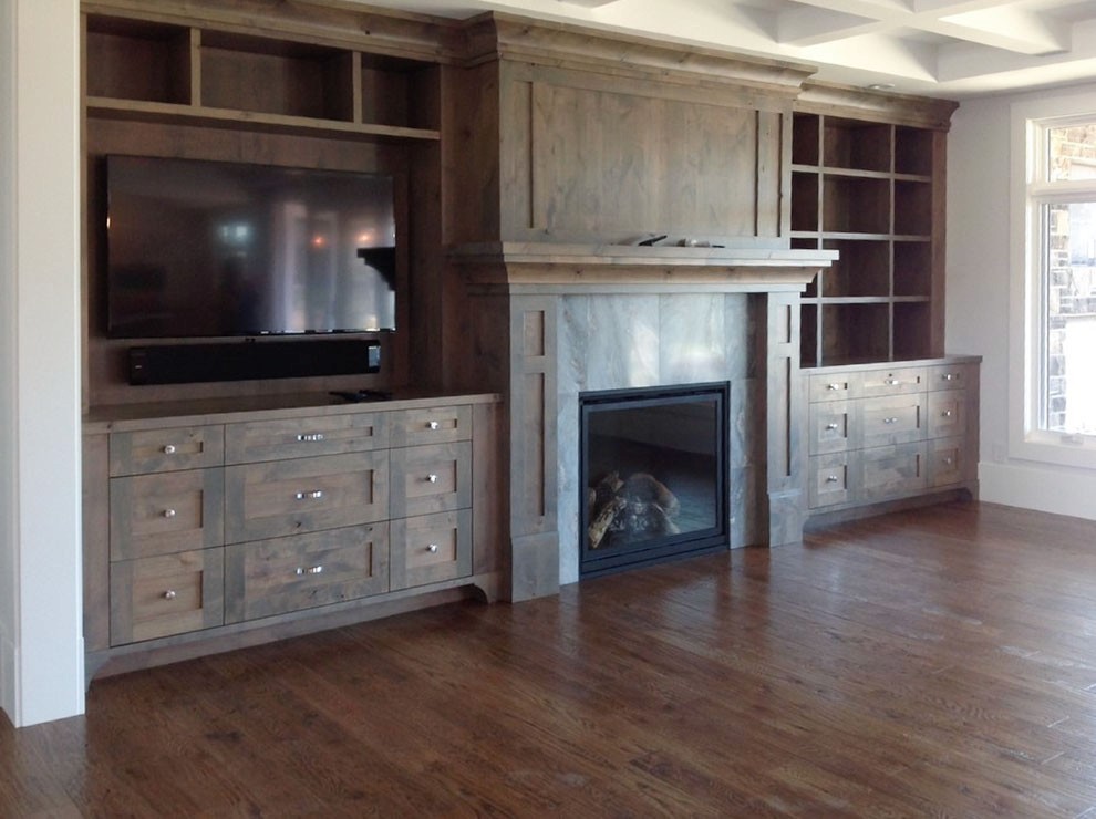 Image of Custom built-in shelving and cabinetry surrounding a stone fireplace in a luxury home by KHD Homes.