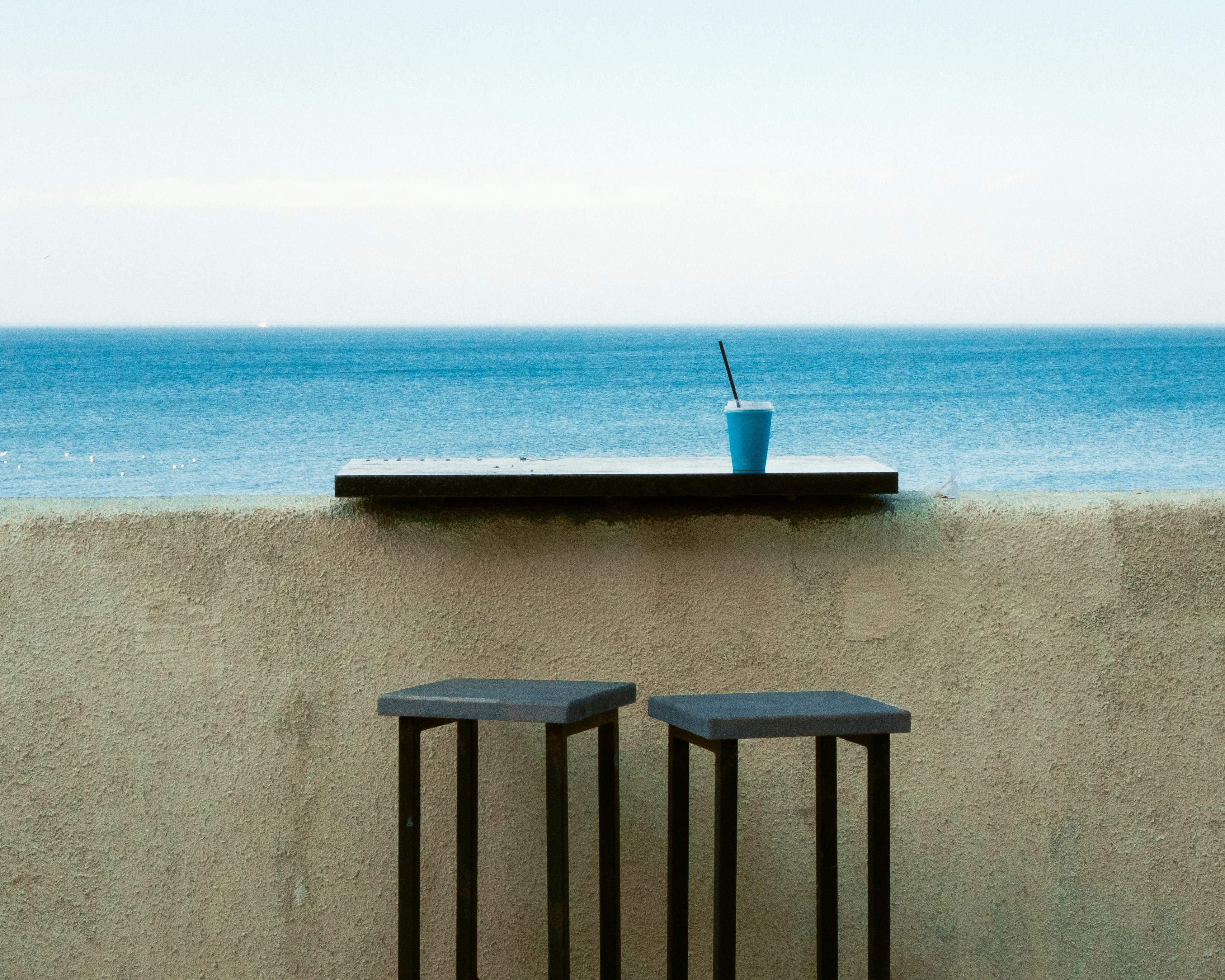 Two stools and drink by the ocean