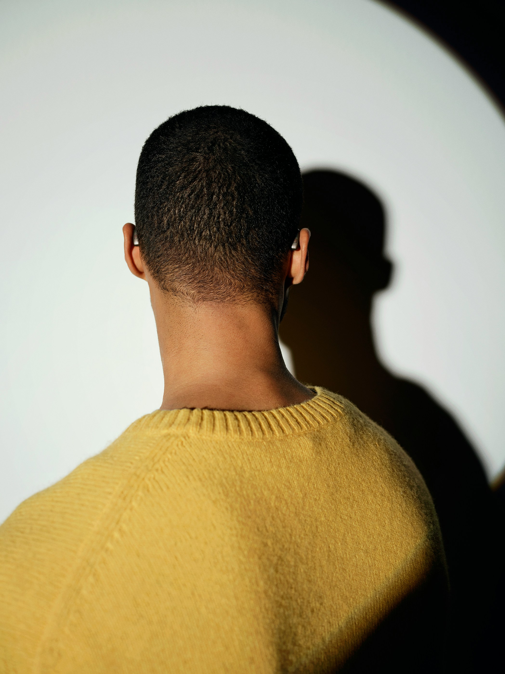 Back of man's head wearing a yellow sweater