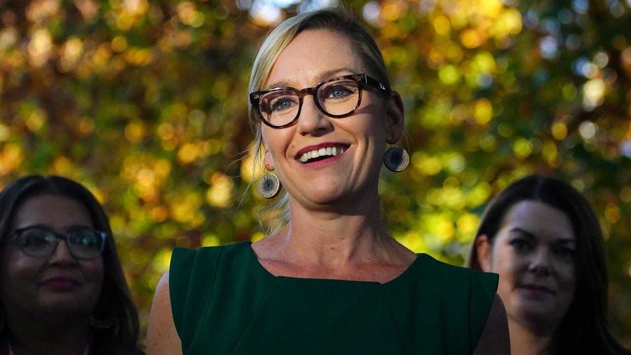 A fast black sports car races down the highway.