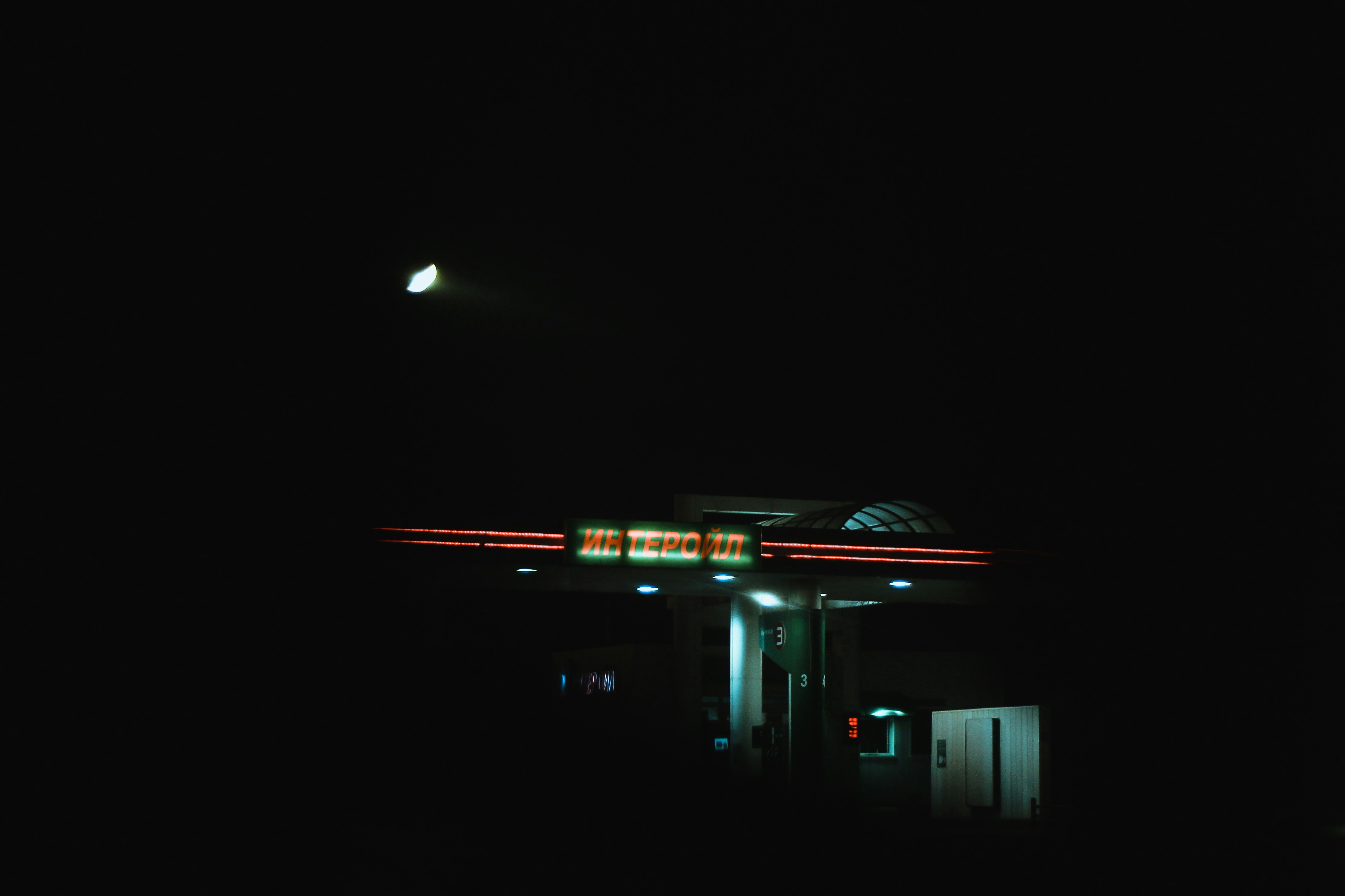 a gas station lit up at night time