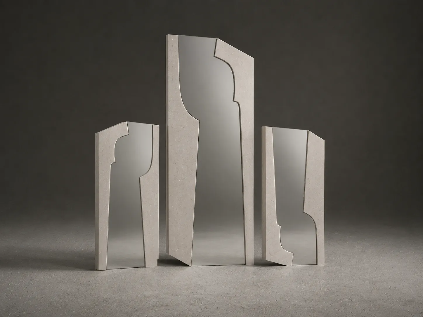 Three Peria sculptural mirrors in different proportions, framed by asymmetrical natural stone profiles and displayed in a studio setting.