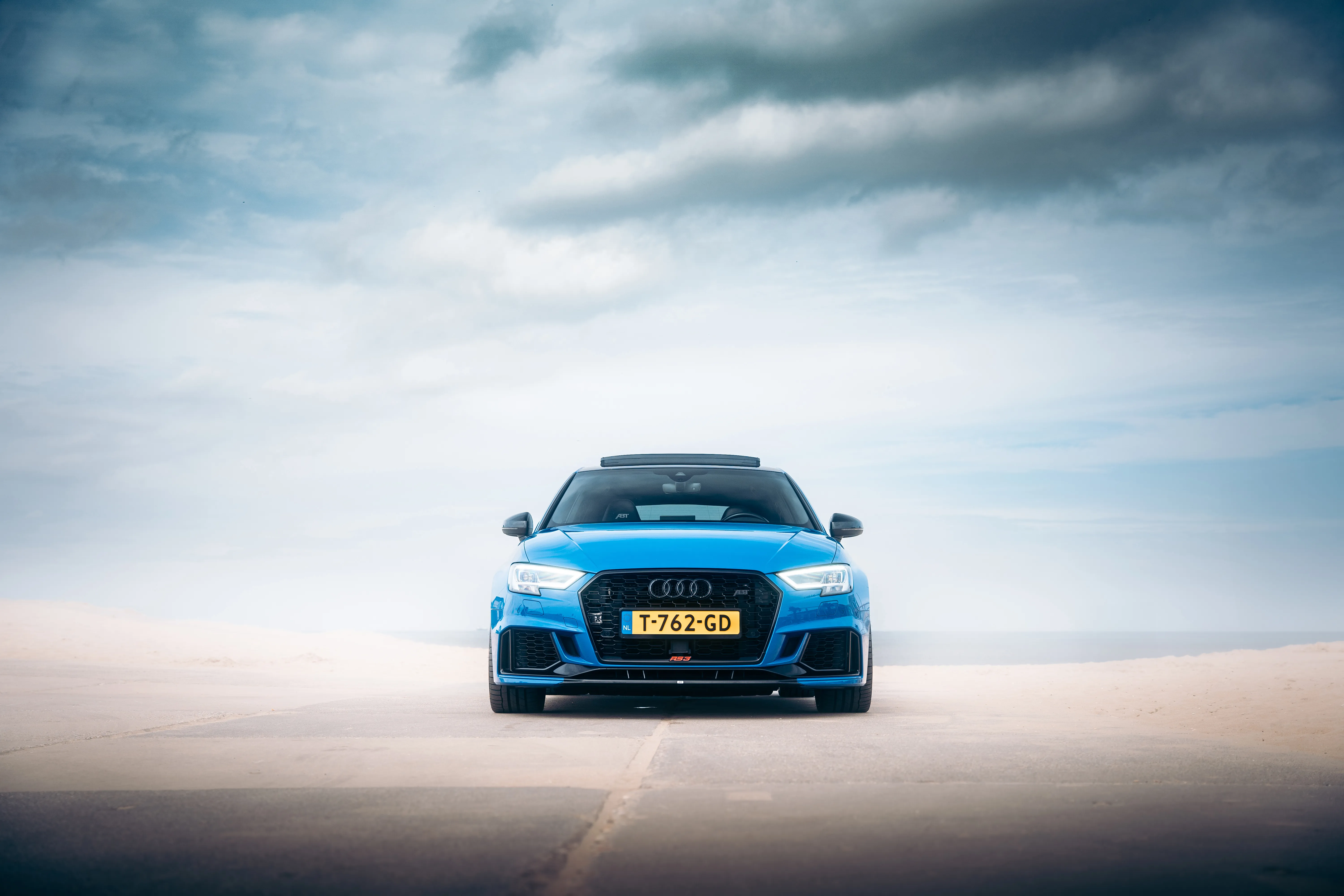 Frontside shot of an blue Audi inside a beach environment