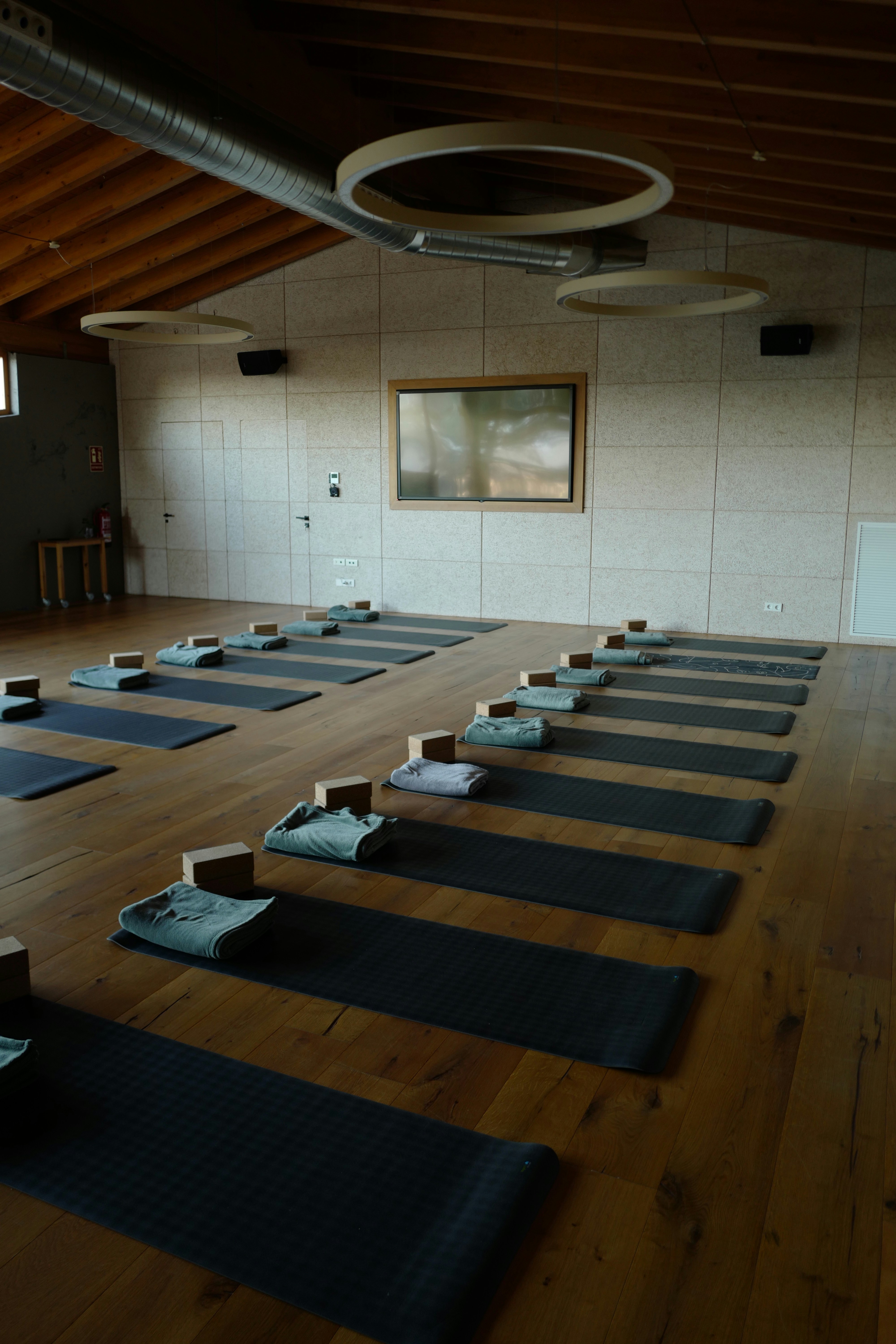 Une salle remplie de tapis de yoga sur un parquet en bois