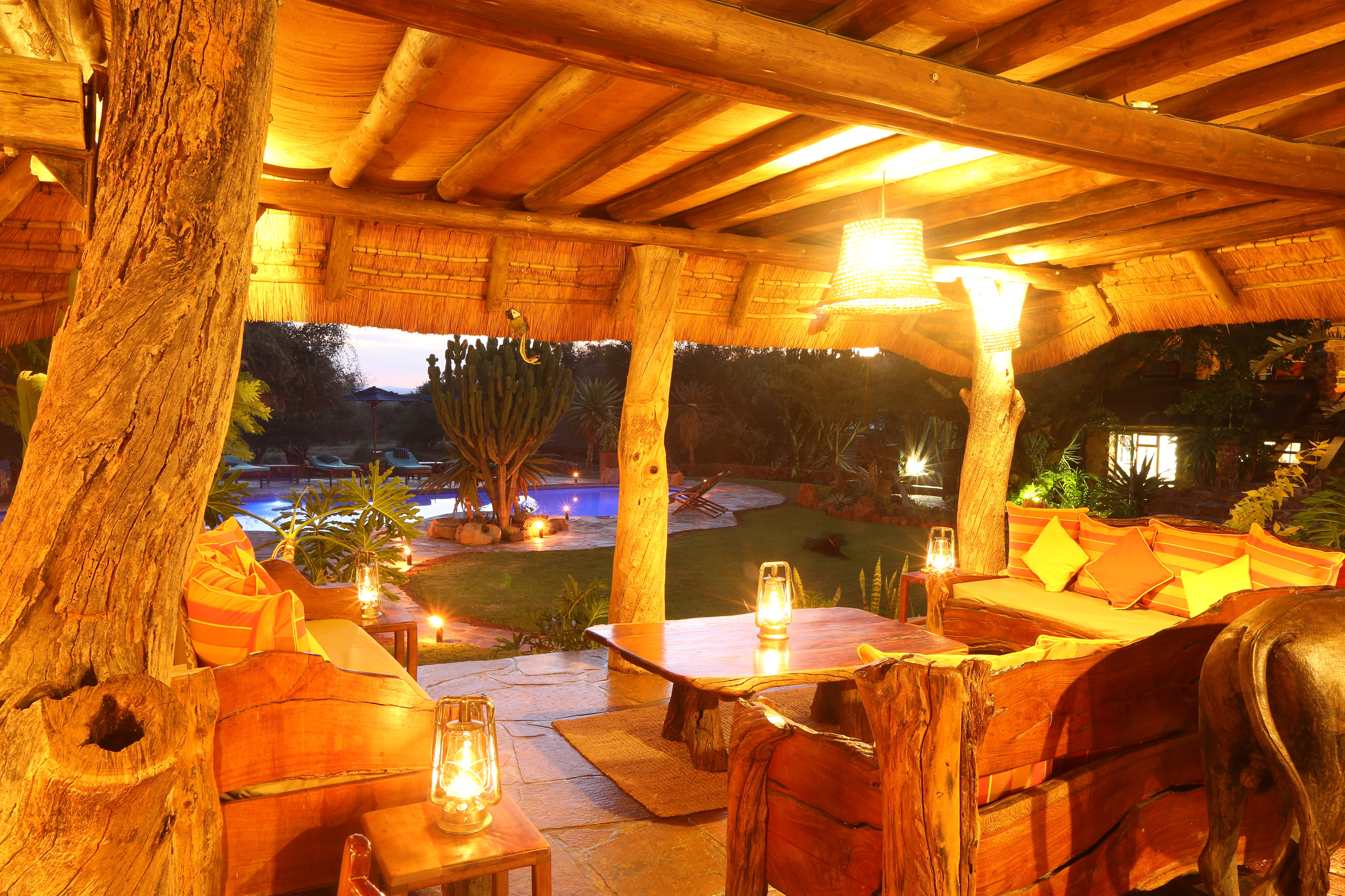 Grupp av ryttare på ridresa i Afrika galopperar över Serengetis vidsträckta slätter medan damm och gnuhjordar rör sig över horisonten under the great migration.