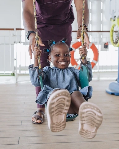 Volunteer pushing a child on a chair