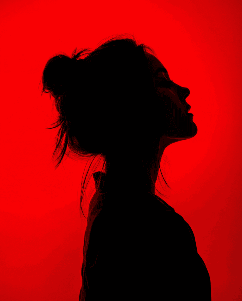 Portrait of a woman lying down with dramatic shadows and low lighting.