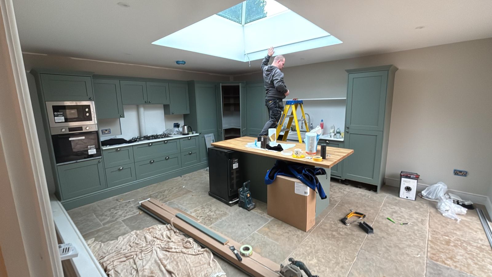 Modern indoor space with large glass doors, lush greenery, and a cozy seating area visible beyond.