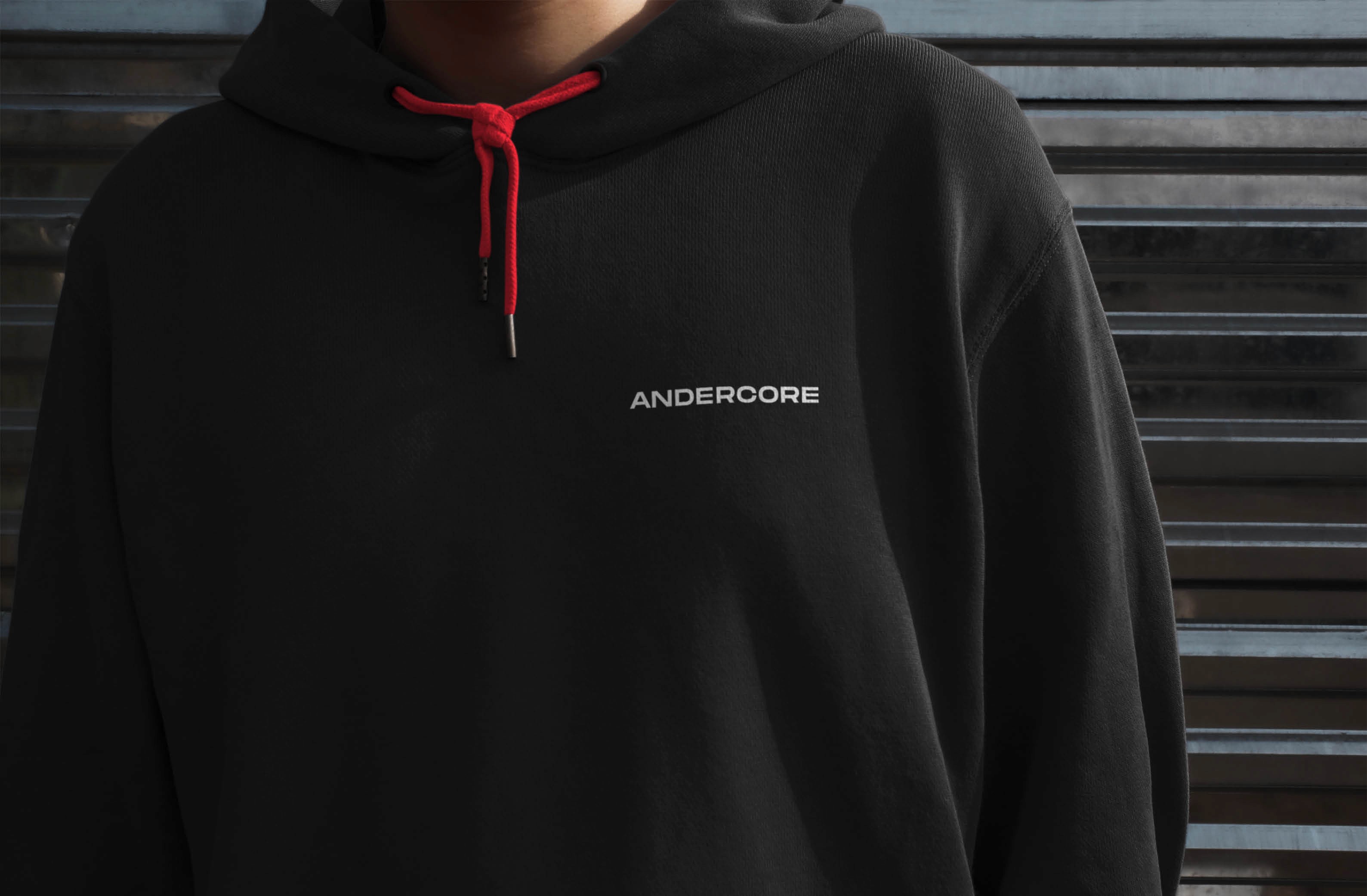 Close-up of a person wearing a black hoodie with red drawstrings and 'ANDERCORE' logo.