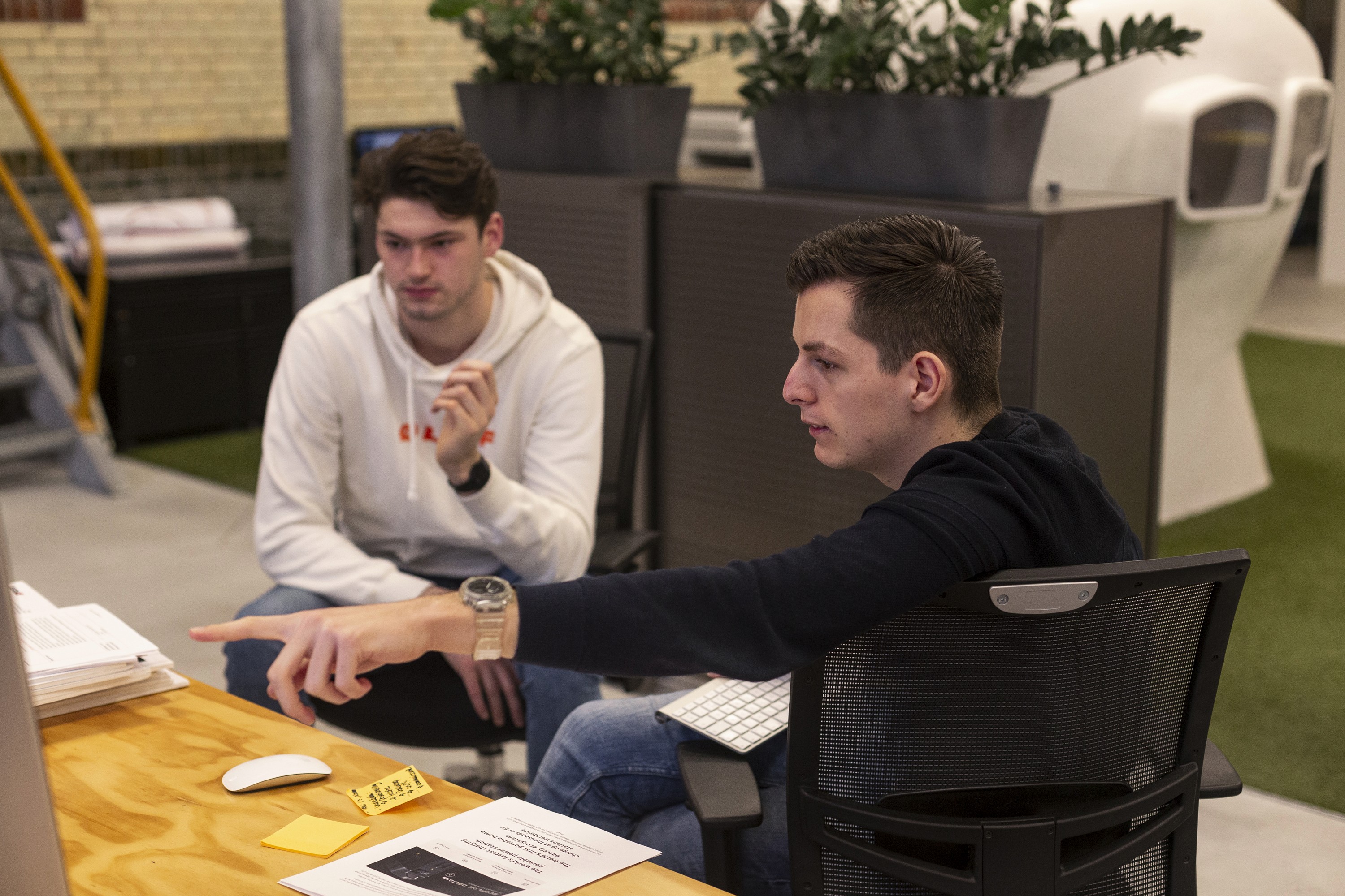 several people in a meeting. One is pointing
