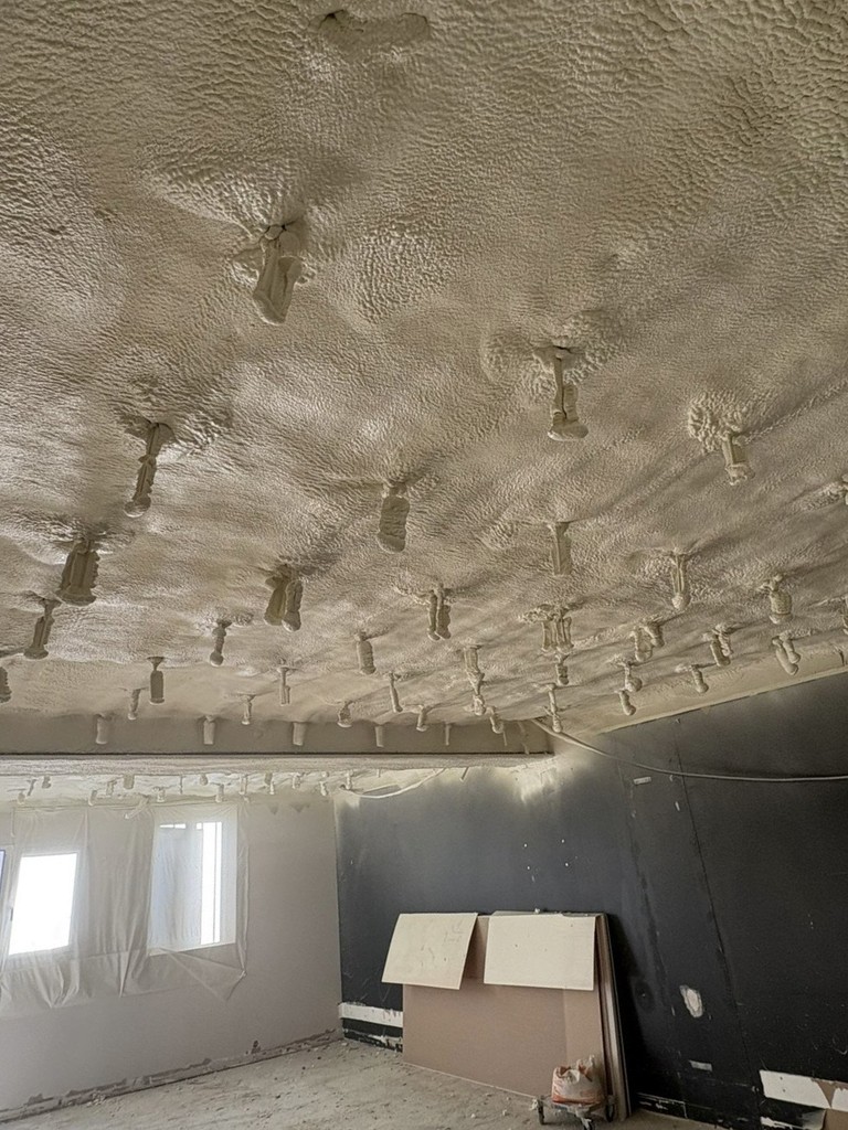 Plafond recouvert de mousse de polyuréthane projetée, offrant une finition homogène et durable