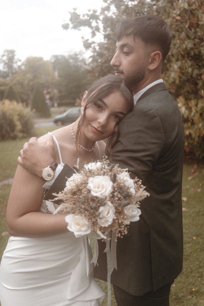 Vintage red Cadillac decorated with white lace ribbon and fresh flowers for a French wedding — elegant detail from a timeless celebration. Cadillac rouge vintage décorée d’un ruban de dentelle blanche et de fleurs fraîches pour un mariage français — détail élégant d’une célébration intemporelle.