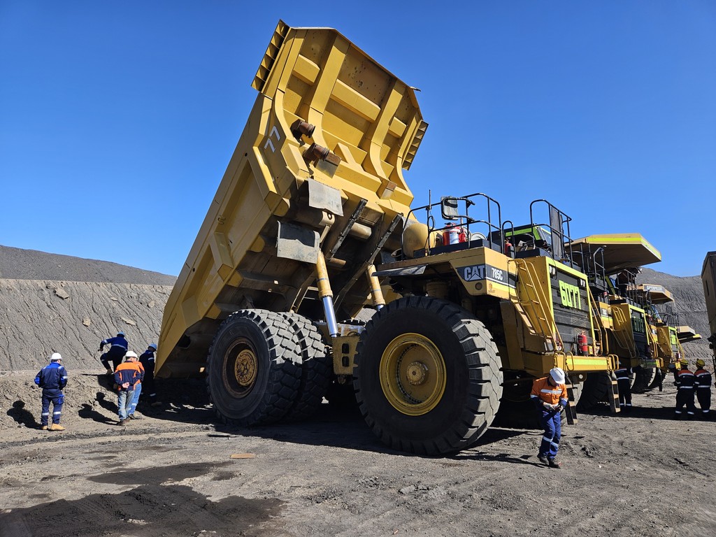 Yellow mining heavy equipment dump trucks. Aftermarket maintenance crew.