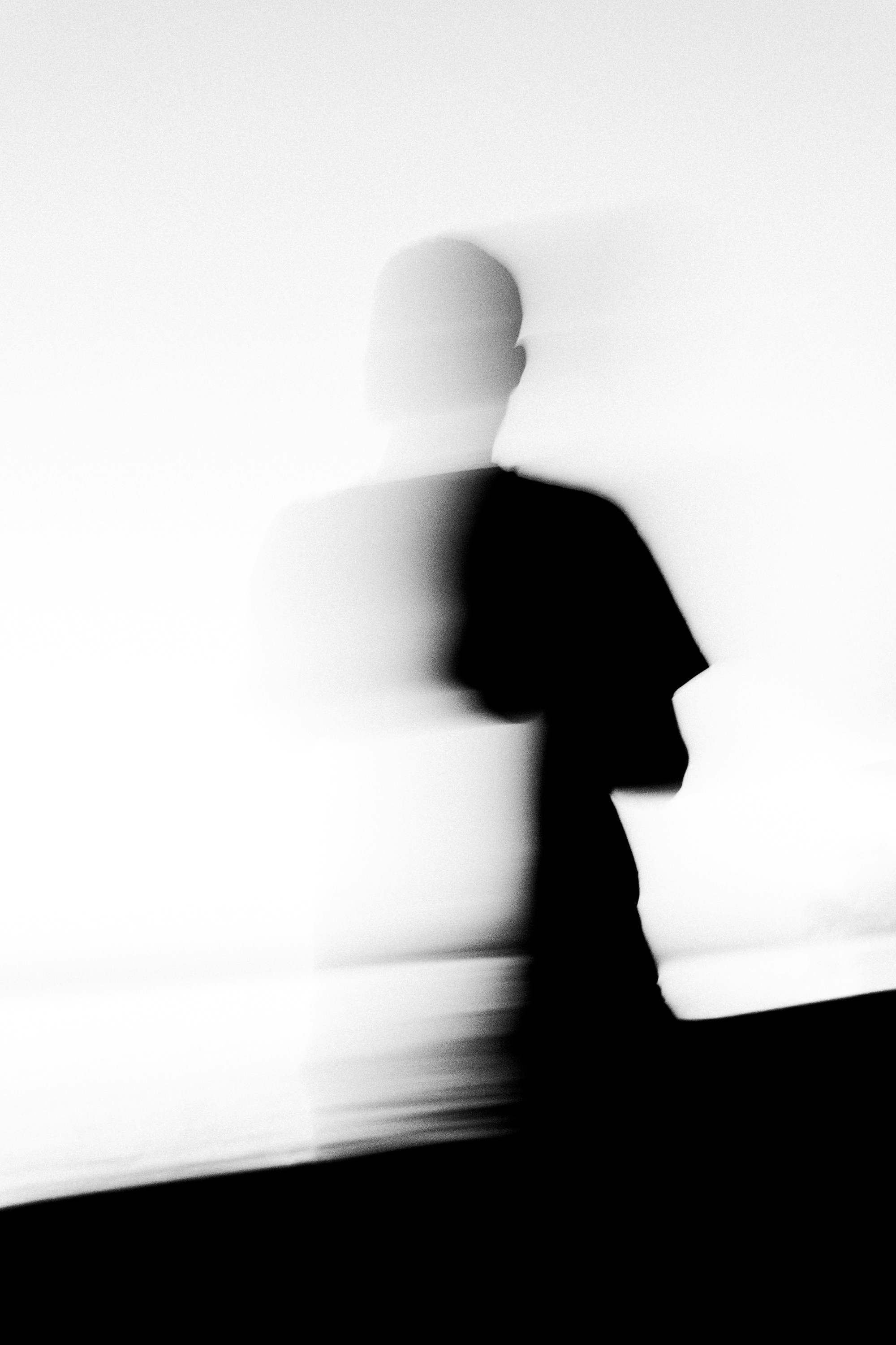 Blurred silhouette of a person against a bright wall