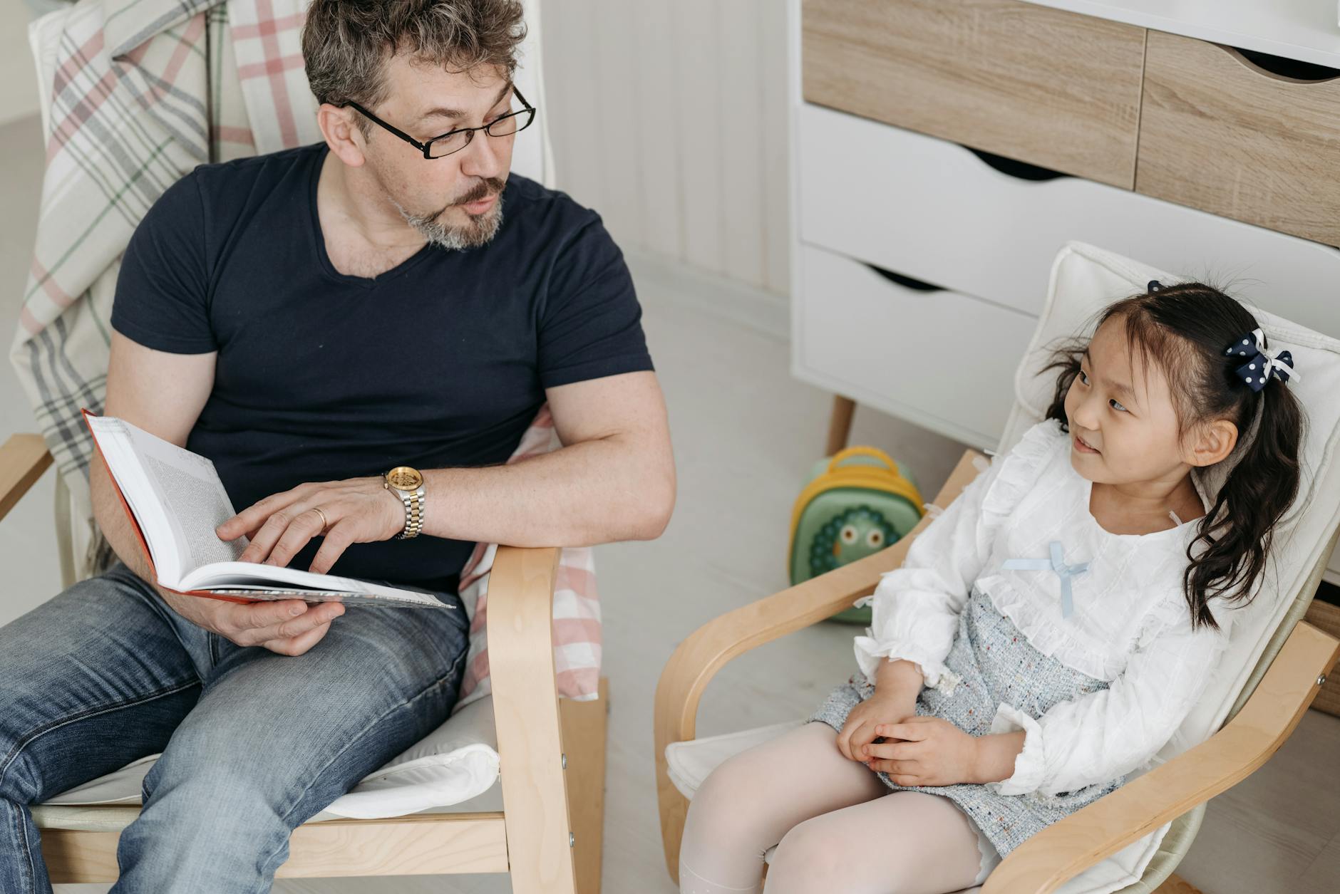 A father and son reading first 100 words books together in bed during a cozy nighttime routine.