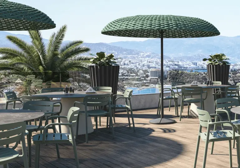 Sillas de exterior para terrazas Croisette en color verde junto a parasoles verder en terraza panorámica con vistas