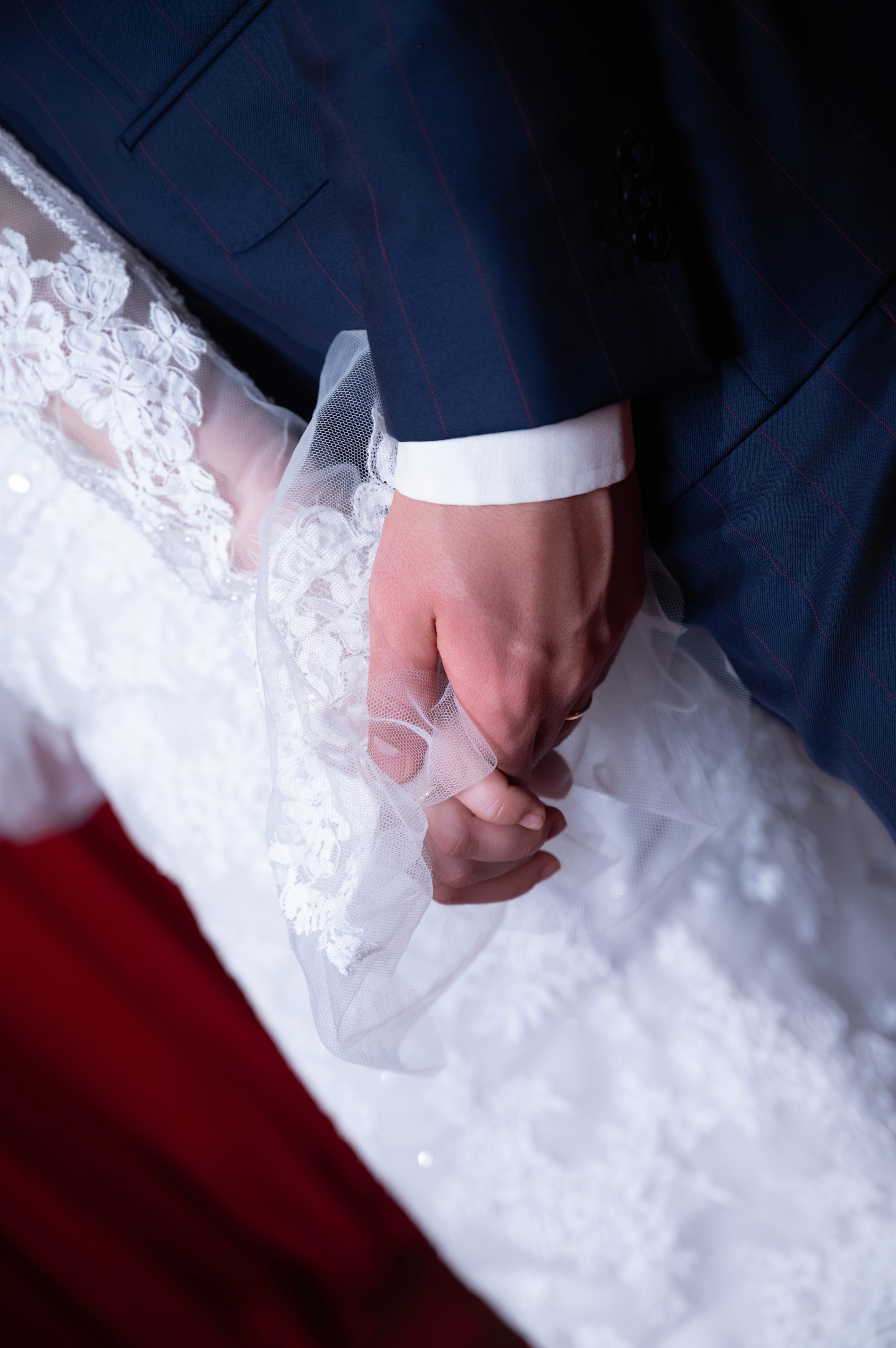 Detaliu cu mâinile mirilor și rochia miresei, fotografie de nuntă elegantă în București