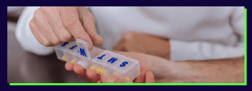 Hands opening weekly pill organizer with labeled compartments.
