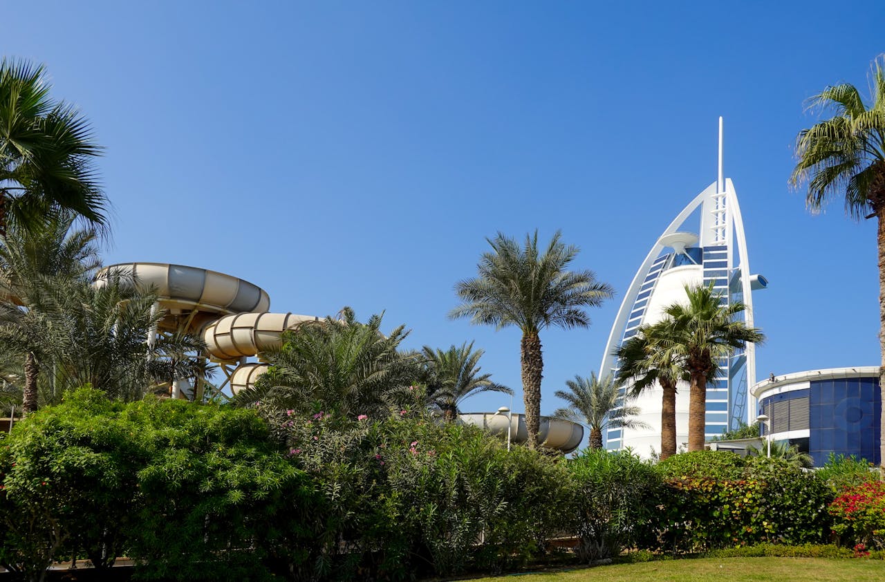 Umm Suqeim Park surrounded by lush greenery, with the Burj Al Arab view in the nearby distance.