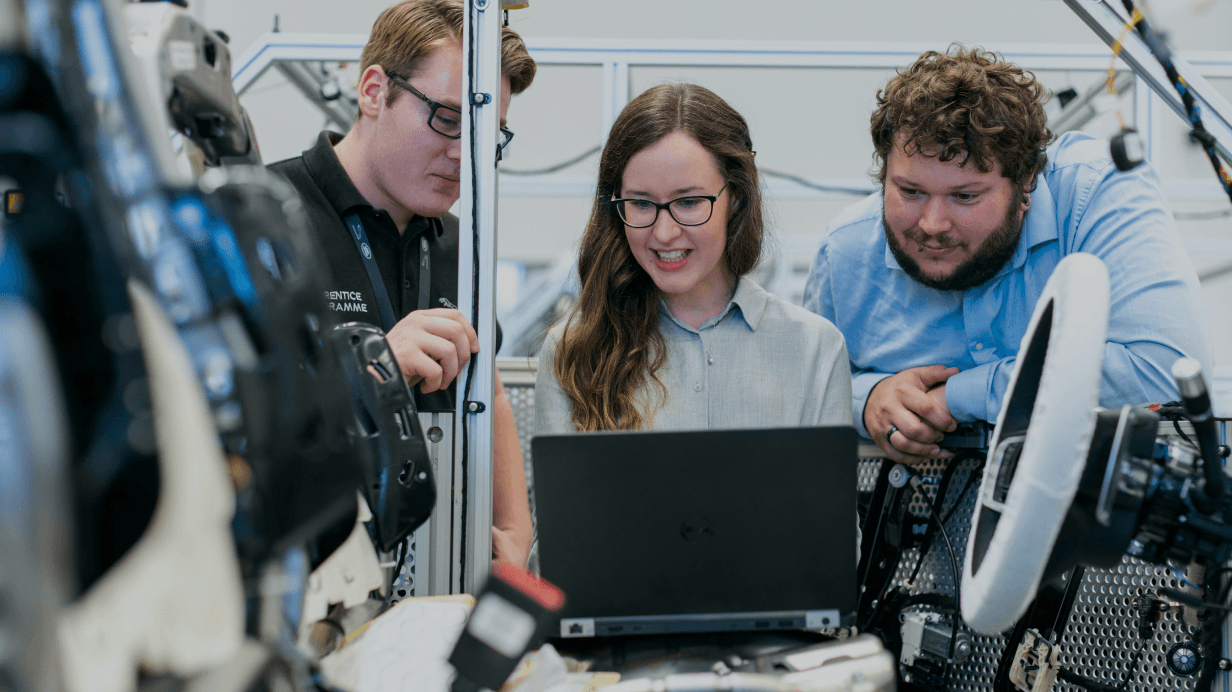 Three people looking at a laptop
