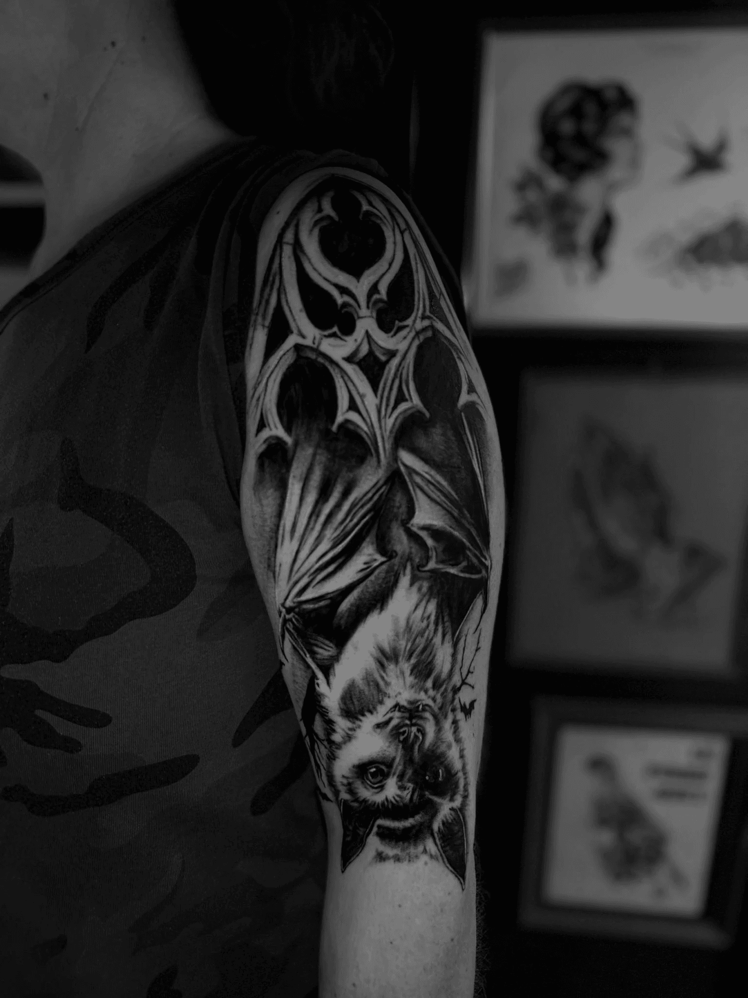 Ein Fledermaus Tattoo mit gotischen Kirchenfenstern in schwarz auf einem Oberarm