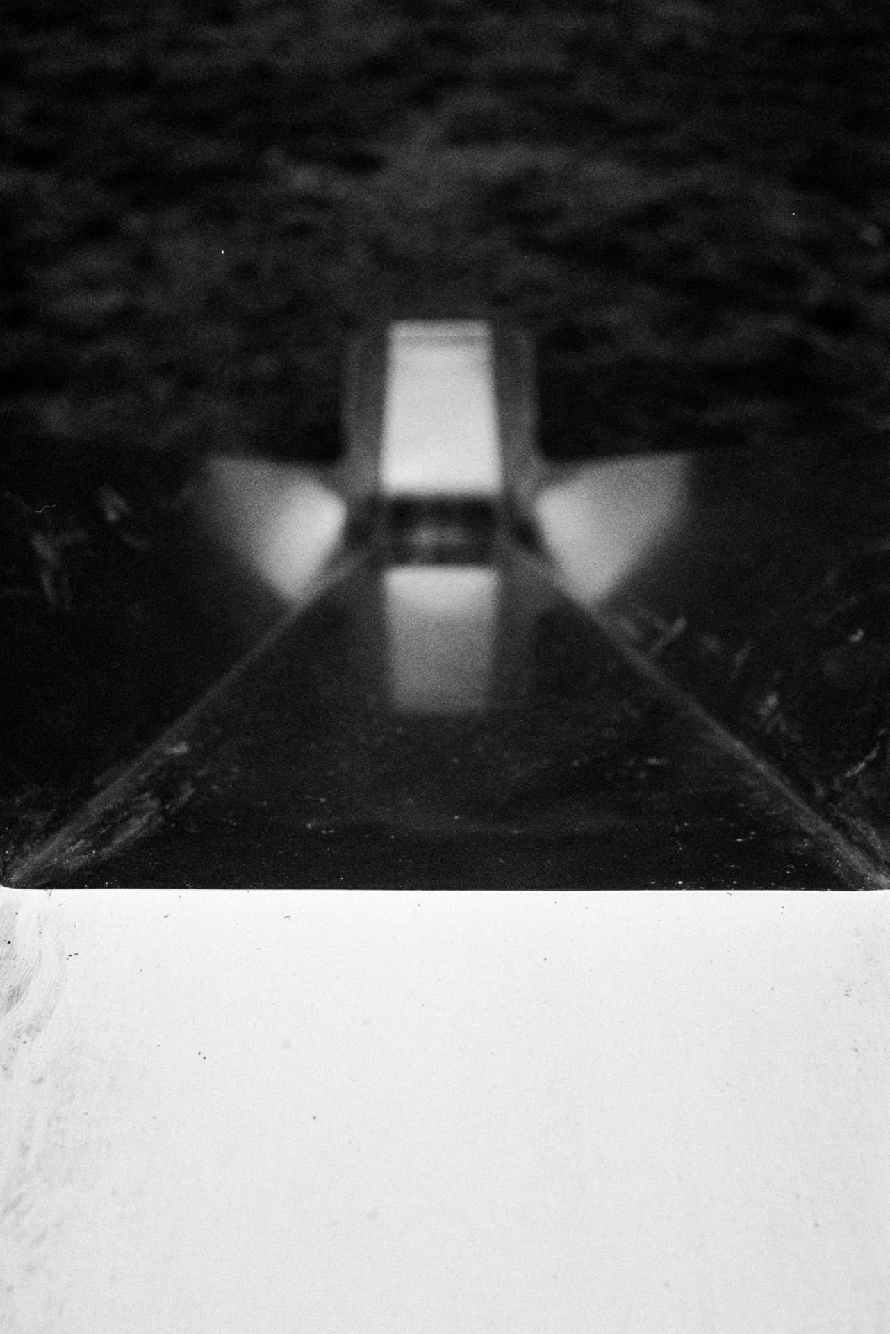 View down playground slide from top with blurred bottom and vegetation visible at exit