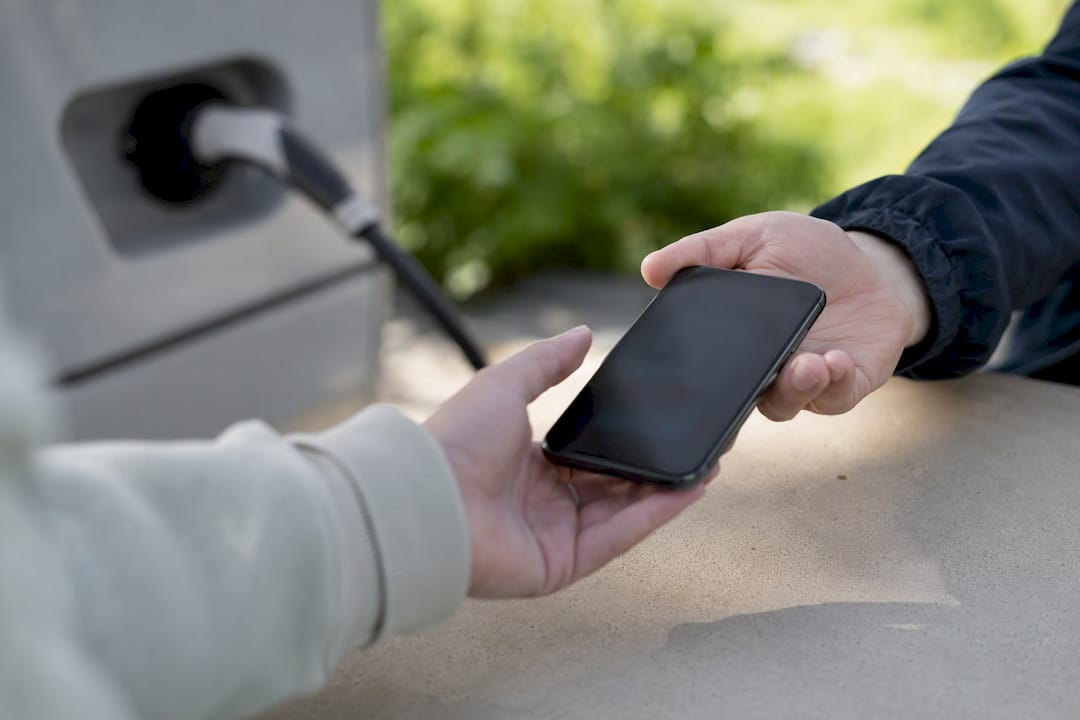 Hender som overleverer smarttelefon med betalingsbekreftelse