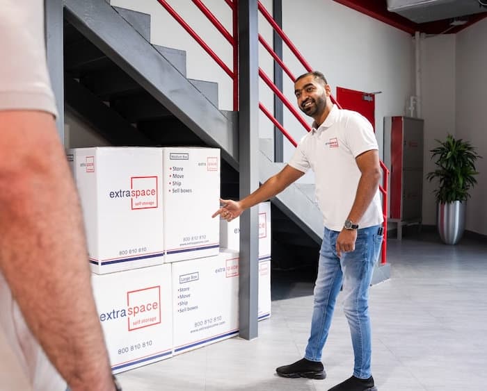 Staff handling branded boxes in a clean facility representing services at self storage Dubai.