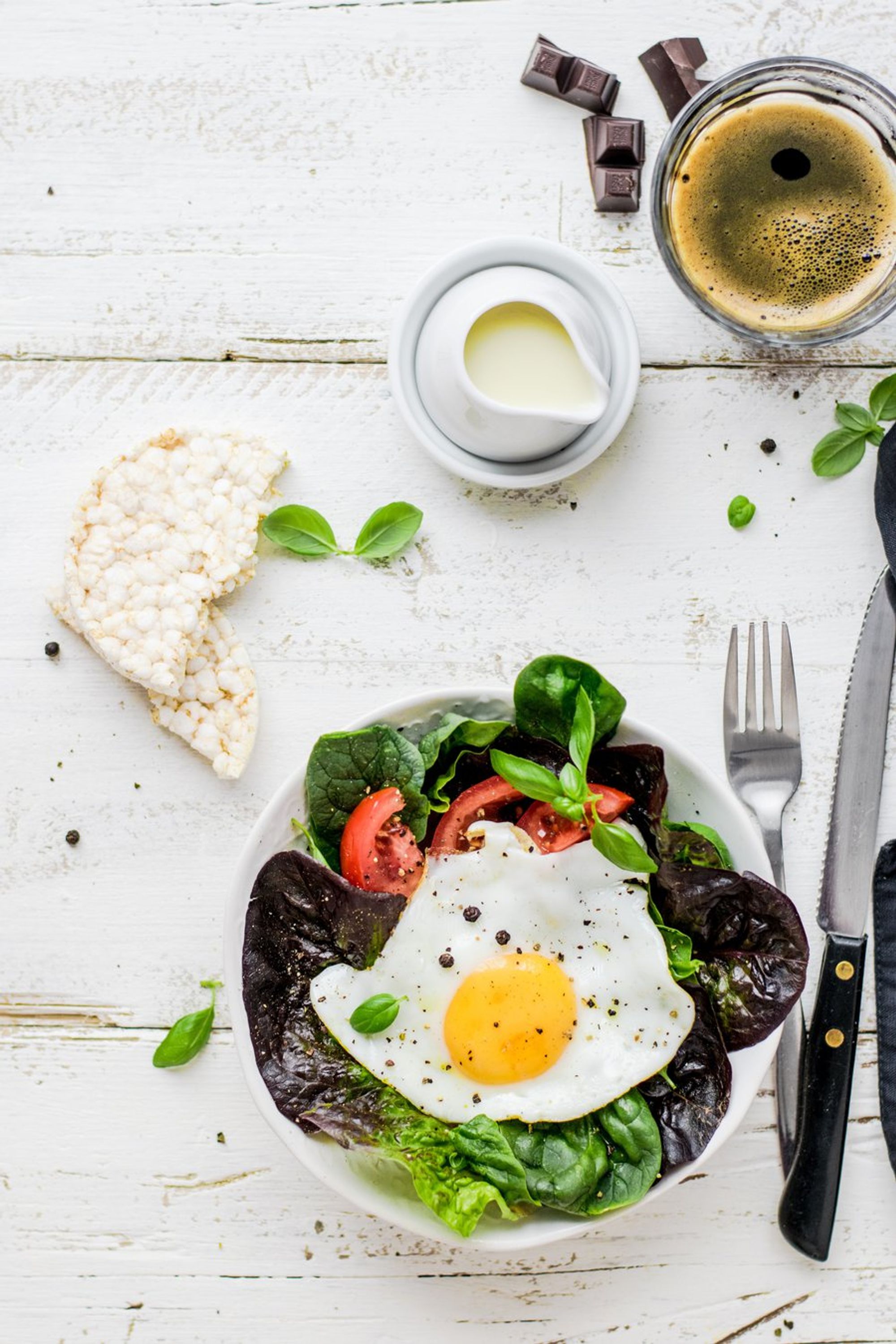 sunny side up egg salad with sides and black coffee
