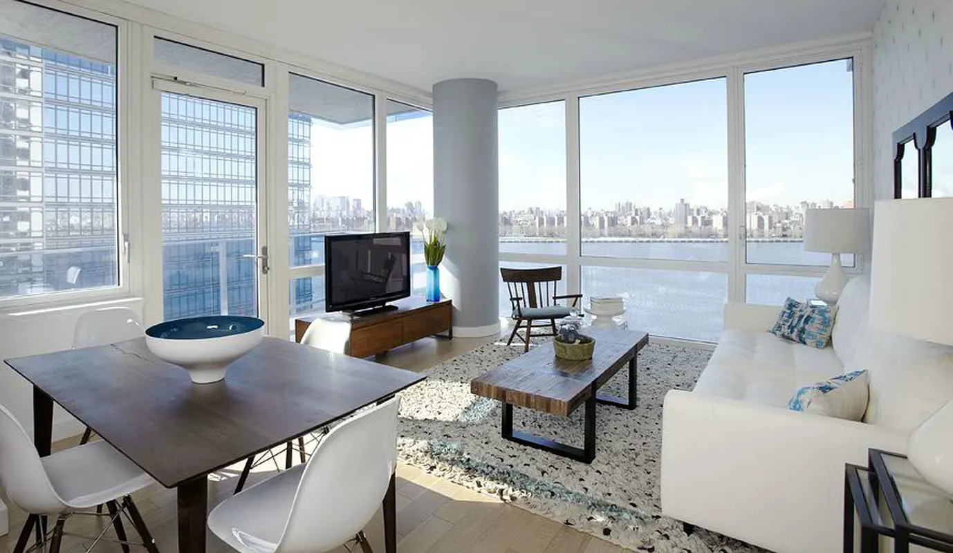 A cozy living room featuring a table, chairs, and a television, creating a welcoming space for relaxation and entertainment.