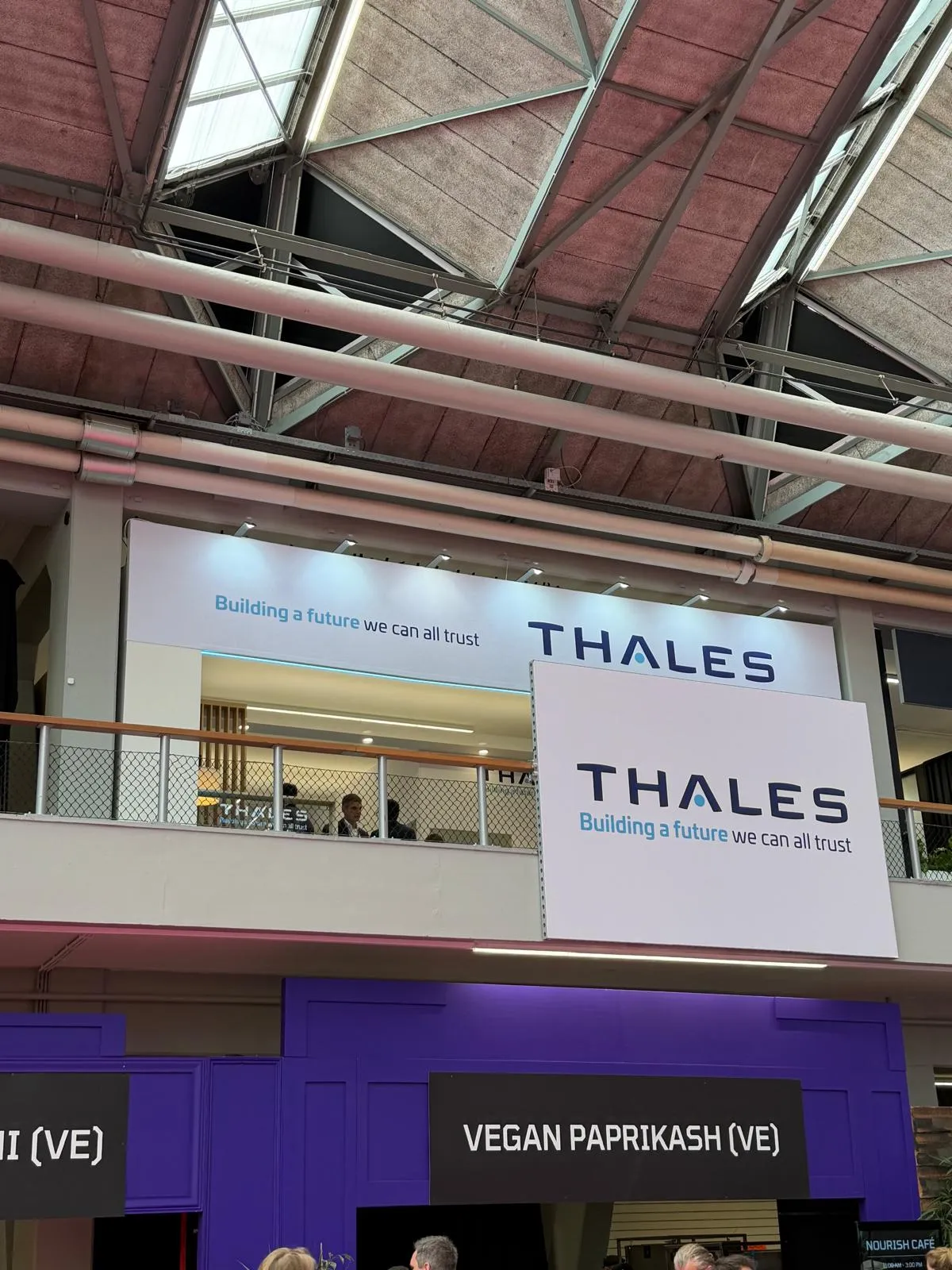 Stand Thales conçu et réalisé par Expace au Money 20/20 Europe Amsterdam – espace sur-mesure avec lounge cosy, claustras bois, jardinières végétalisées et signature « Building a future we can all trust ».