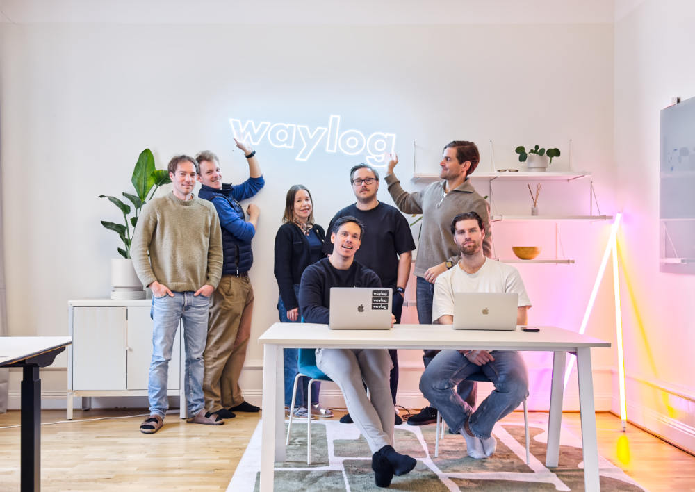 Two colleagues smiling while working together on a laptop.