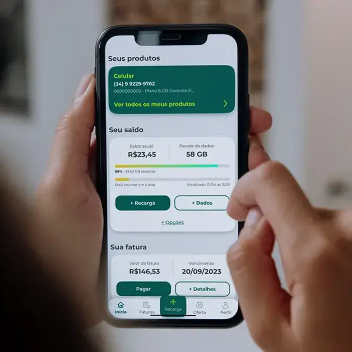 Close de uma pessoa olhando o celular onde na tela está serndo apresentado o novo layout que fiz para o aplicativo da Algar Telcom