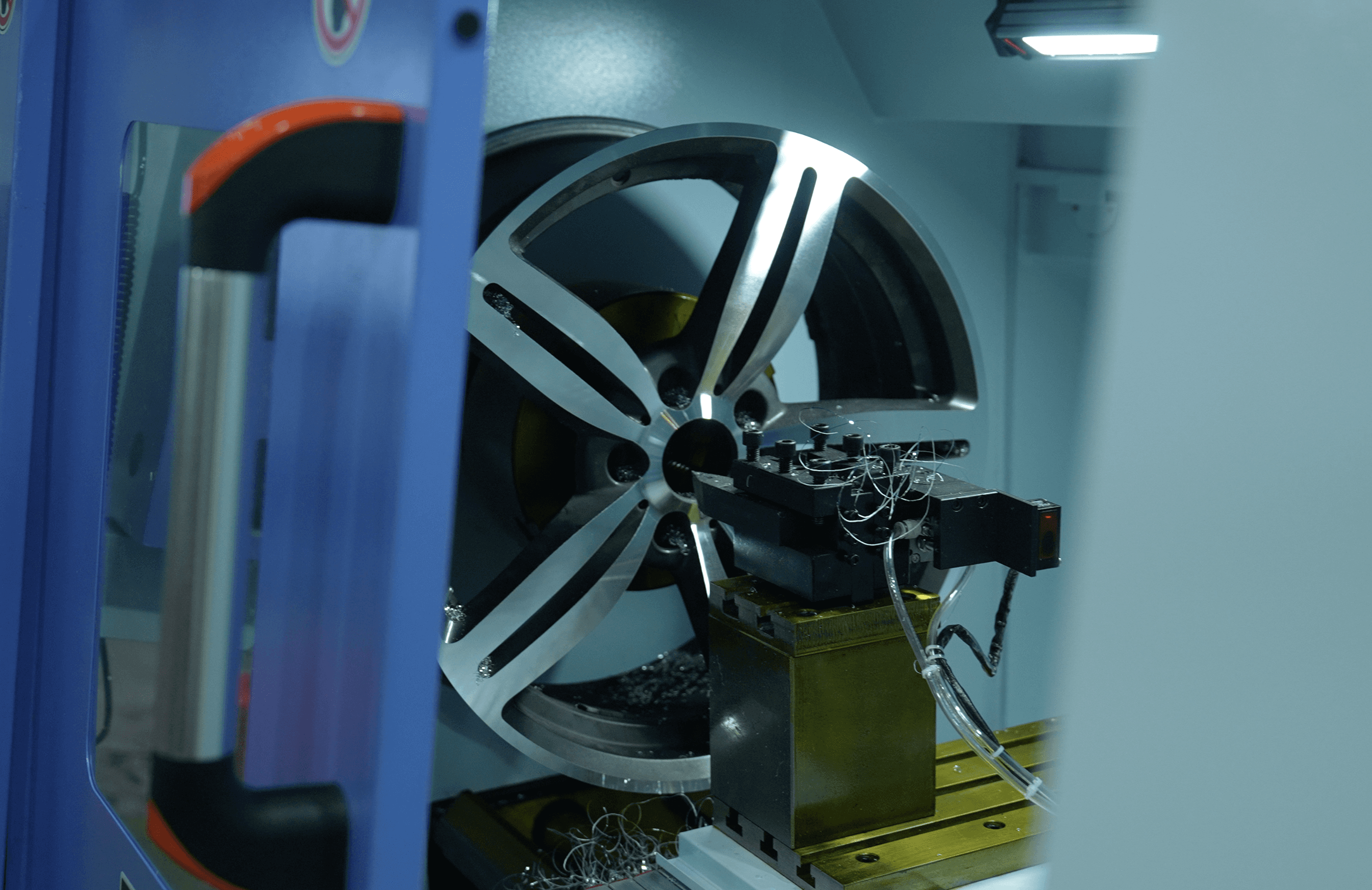 A serene outdoor seating area with two chairs, surrounded by lush greenery and a glassed-in structure.