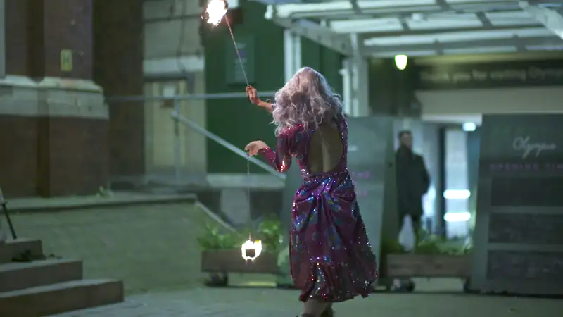Performer in a sequinned outfit spinning fire outdoors as part of evening entertainment at the Gainsight Pulse event.