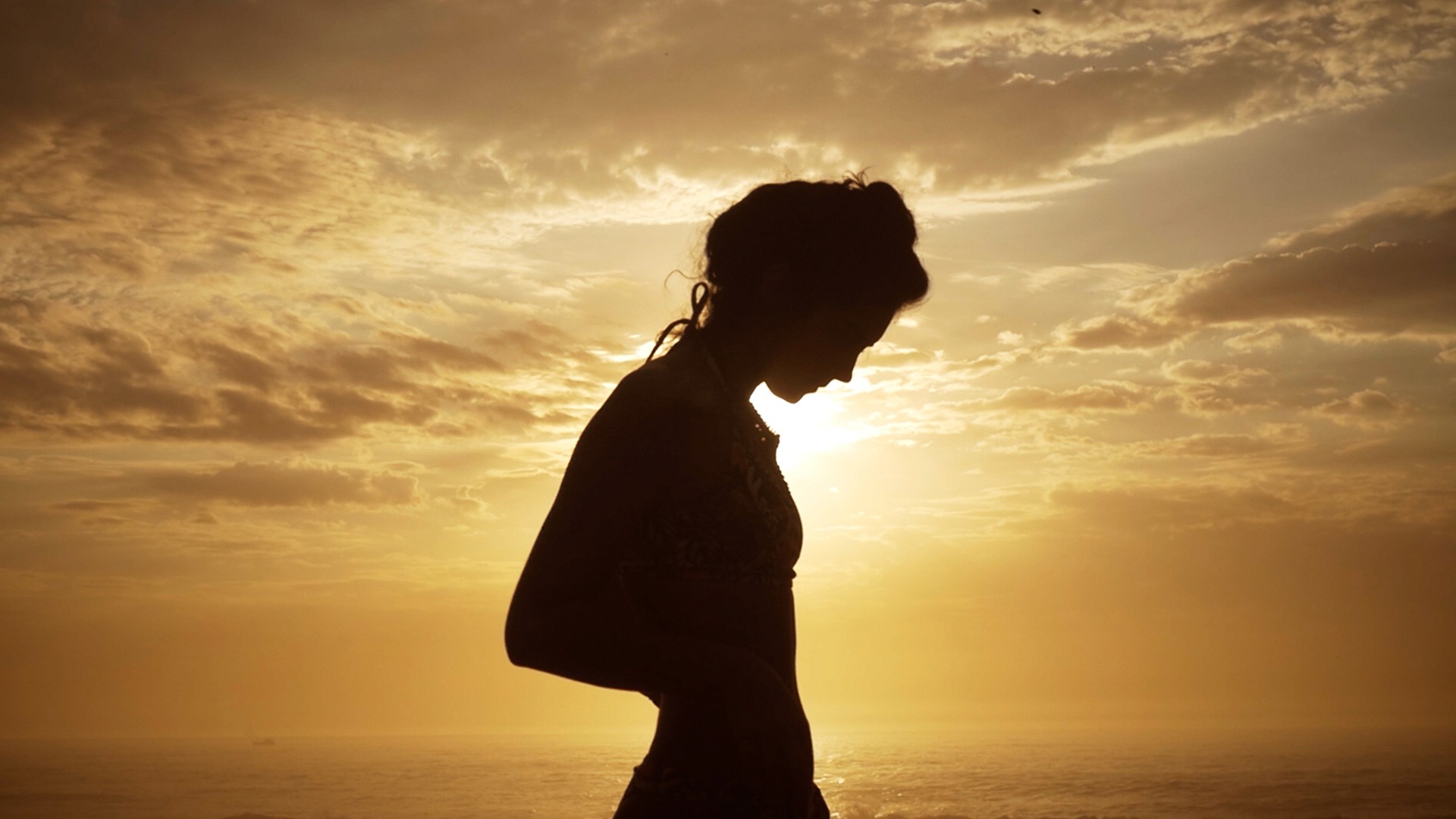 Editorial fashion film of a silhouette of woman in front of the sun